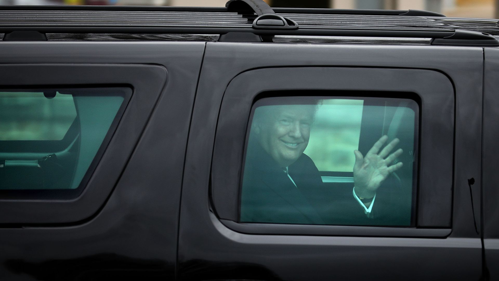 President Donald Trump waves to journalists as he leaves Walter Reed National Military Medical Center. 