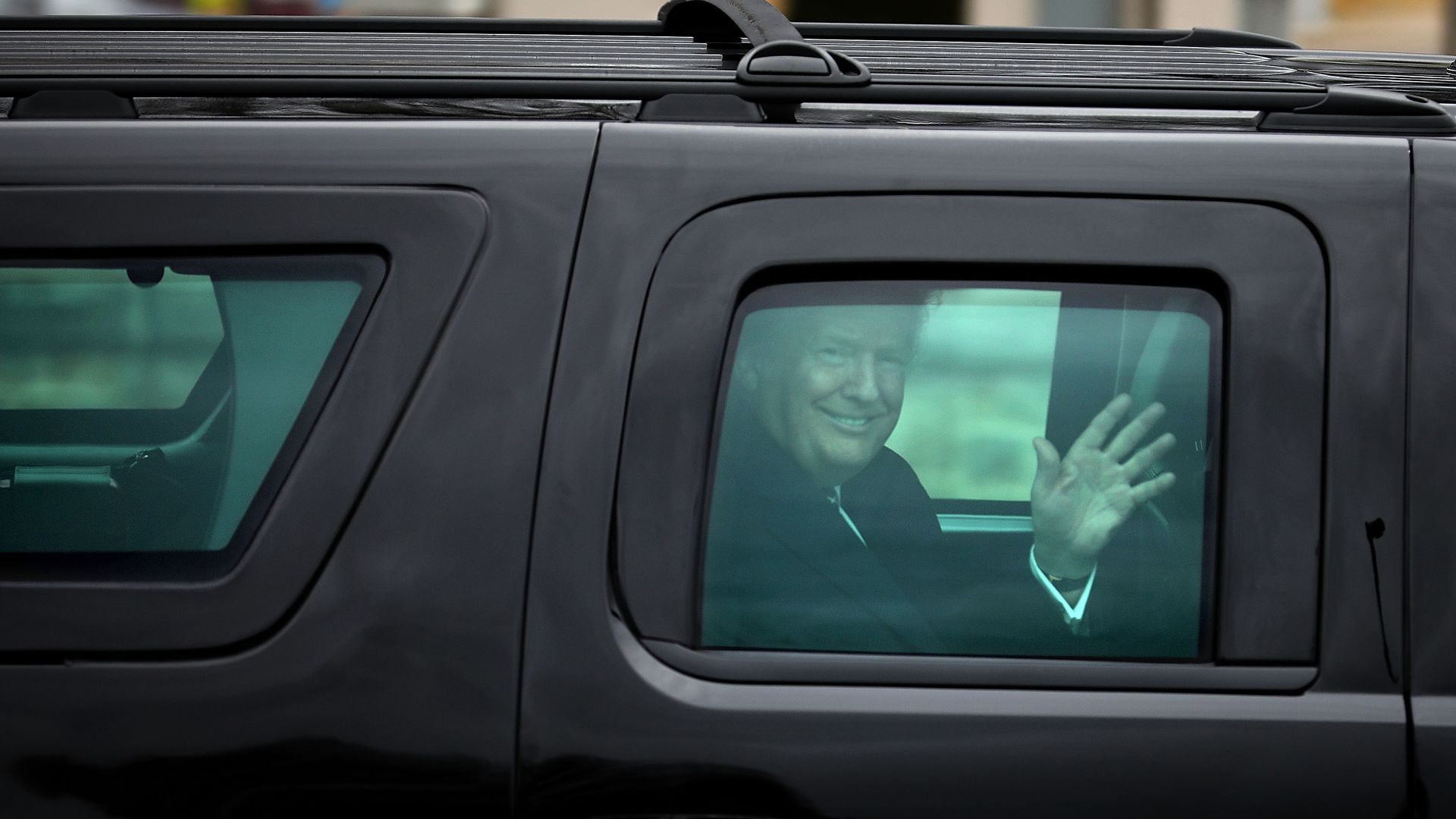 President Donald Trump waves to journalists as he leaves Walter Reed National Military Medical Center.