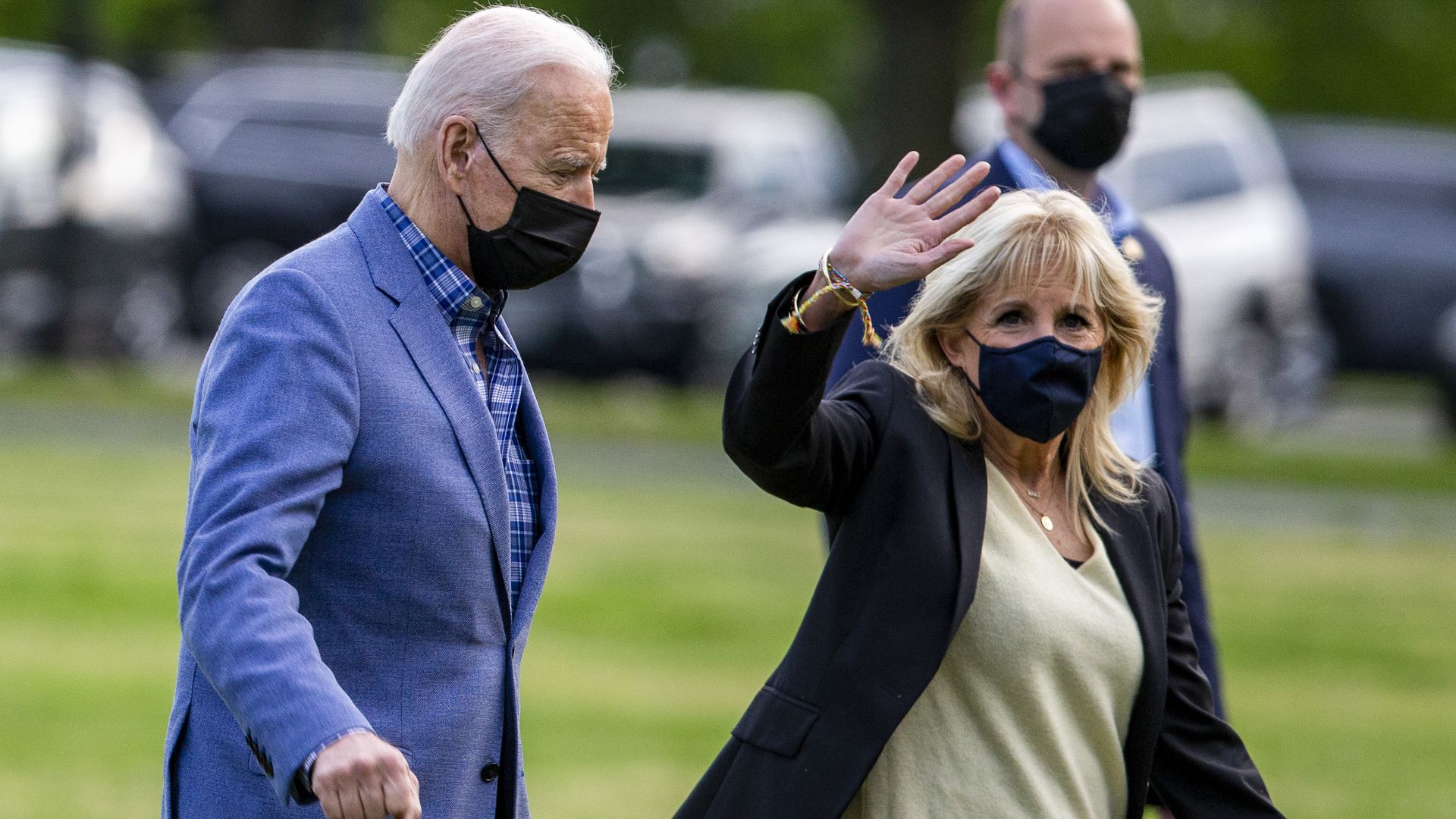 Joe Biden and Jill Biden walk outside while Jill waves