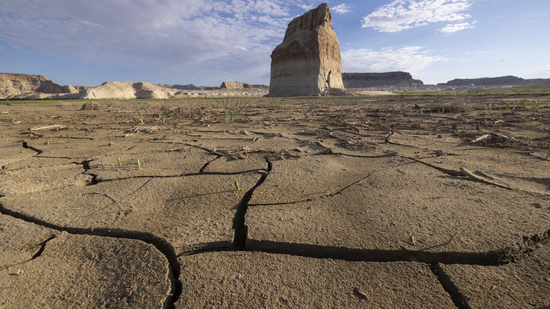  Cracked mud dries in the sun where Lake Powell used to surround Lone Rock, in the distance, on September 2, 2022 near Page, Arizona. 