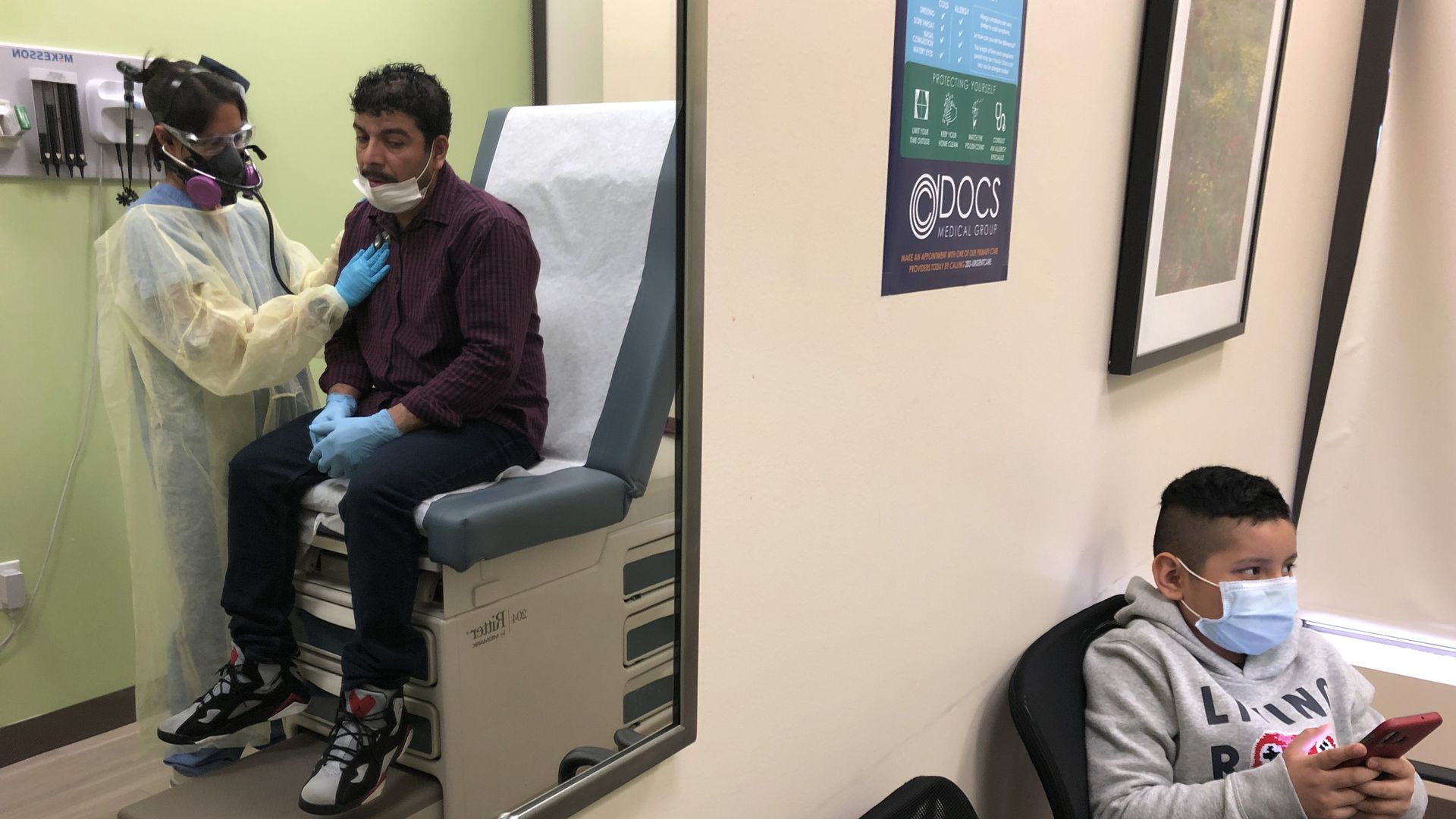 A man sits on an exam chair in a doctor's office while a nurse checks him out, and a kid sits in a waiting room.
