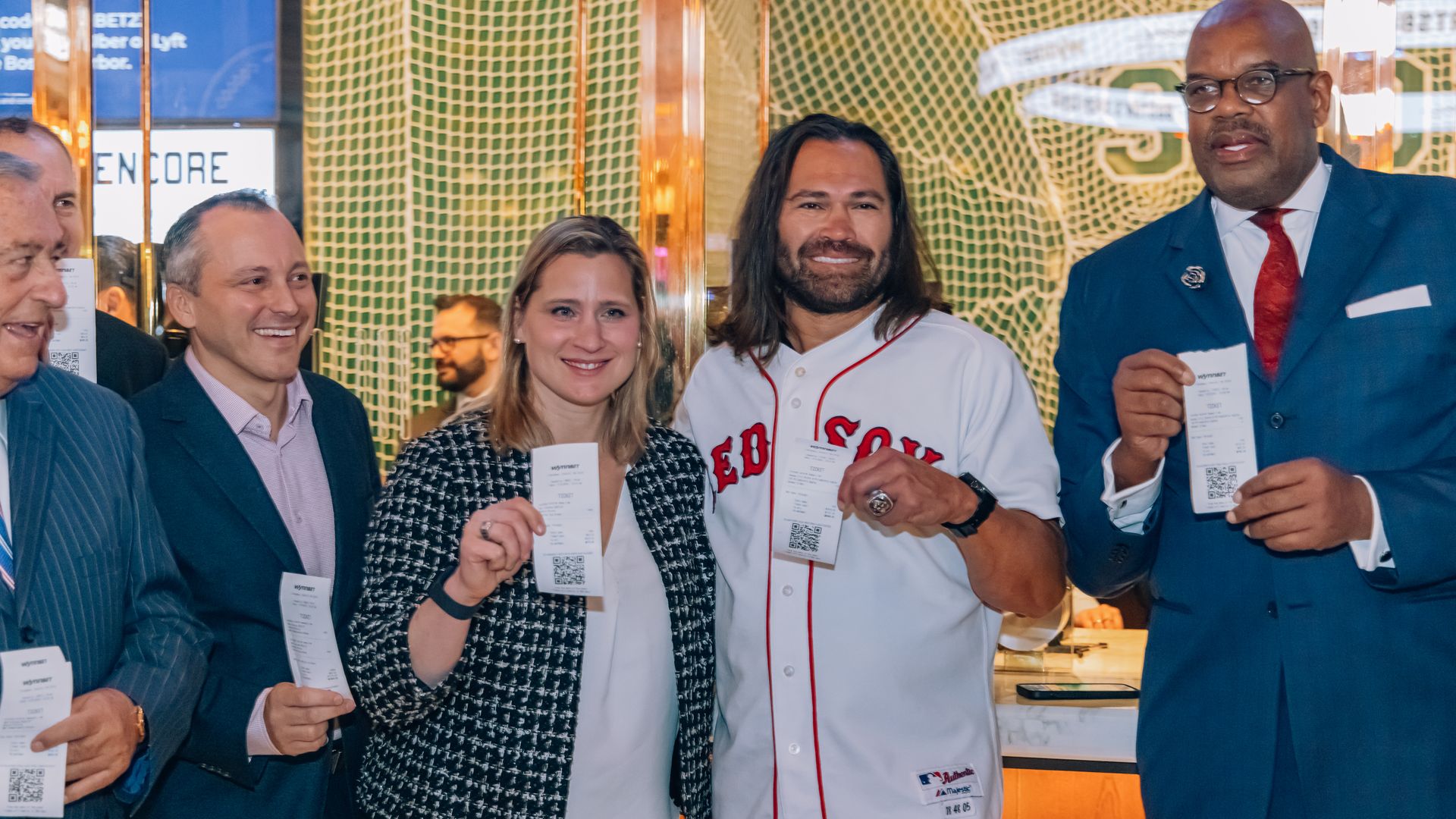 Former Olympic hockey player Angela Ruggiero (center) shows her ticket alongside former Red Sox player Johnny Damon (right) by Encore's betting windows. On the left is Rep. Aaron Michlewitz.