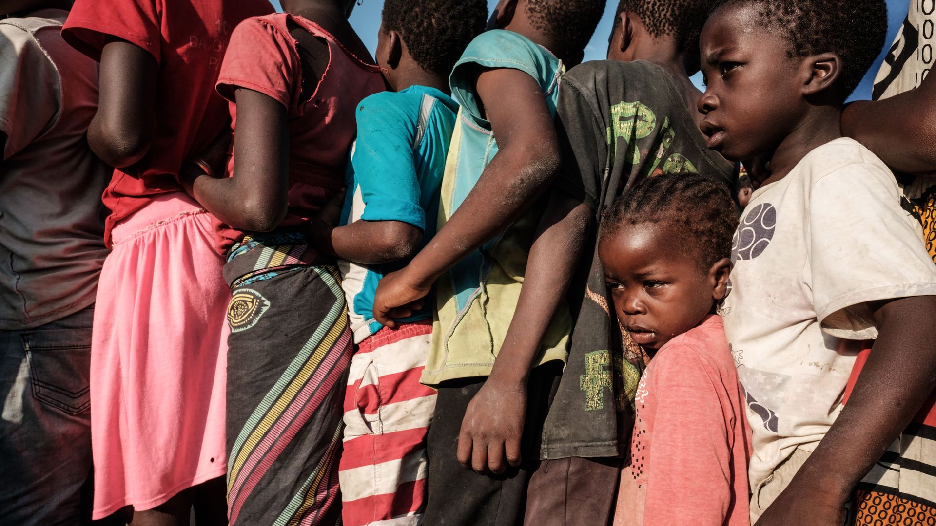 Children in Mozambique wait in line for food following Cyclone Idai