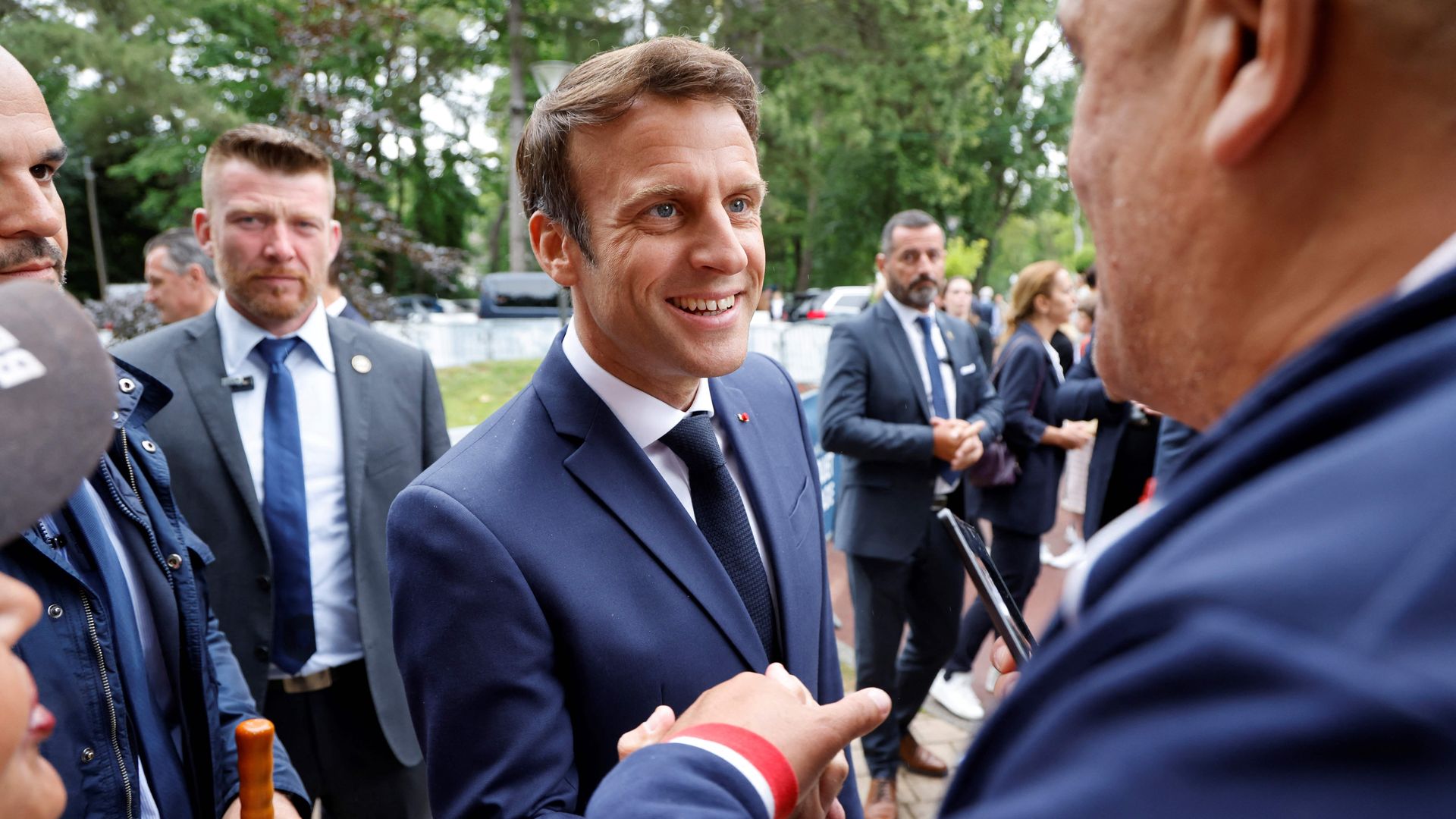 Emmanuel Macron speaks to fellow voters as he arrives to vote