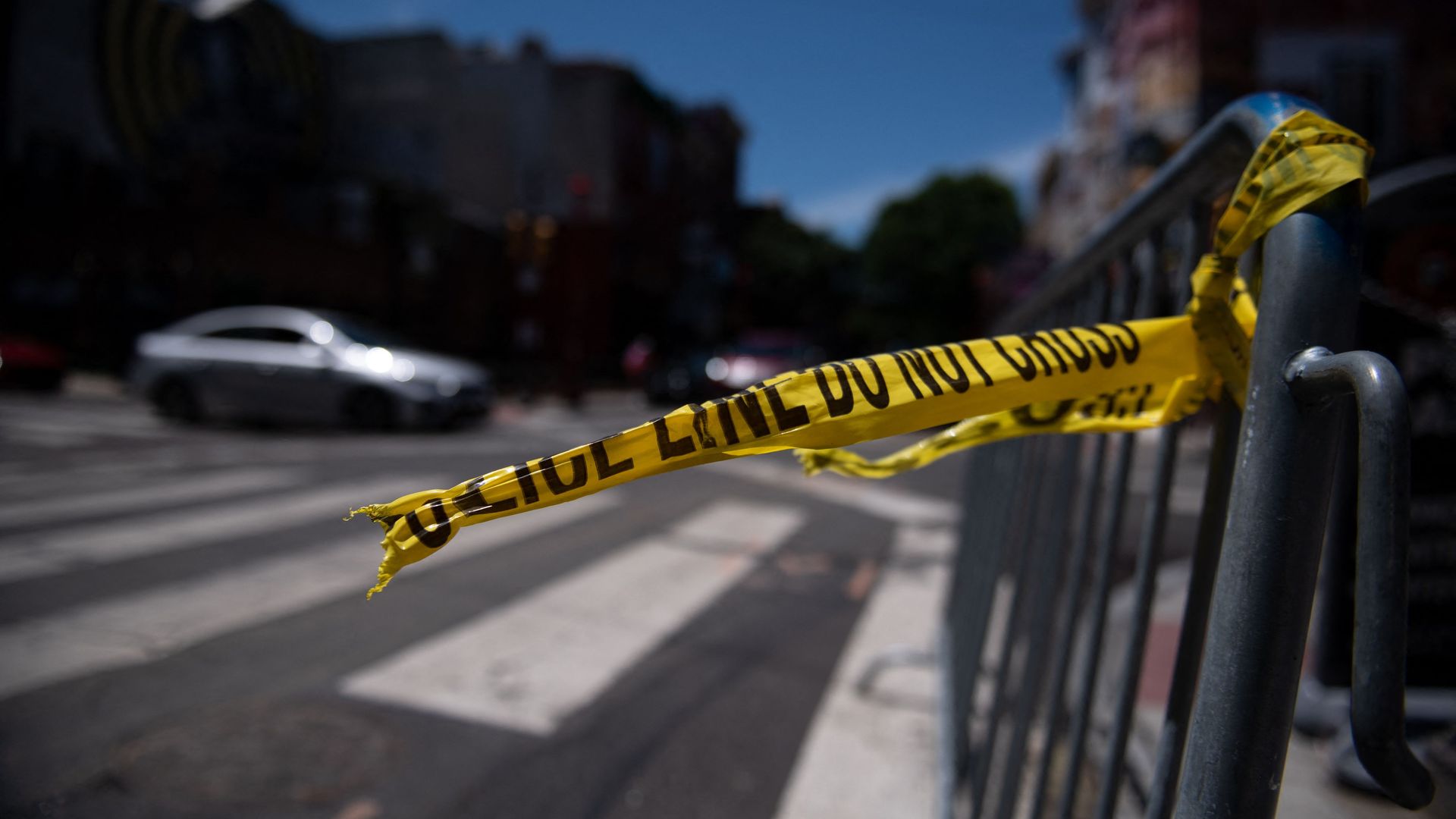 Police tape hangs from a barricade