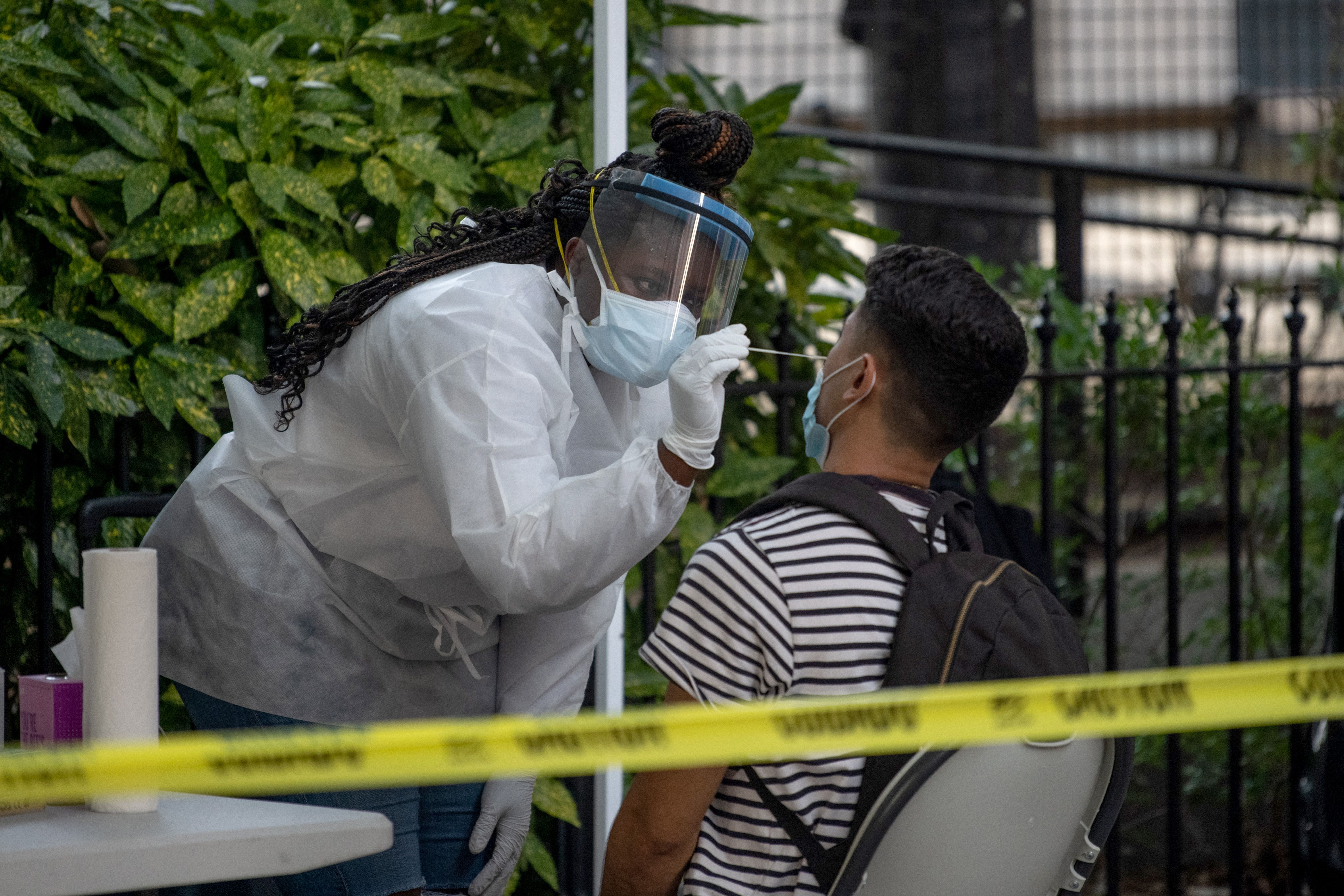 A New York medical worker wearing PPE administers a nasal swab test at a free coronavirus testing location outside Washington Square Parkas 