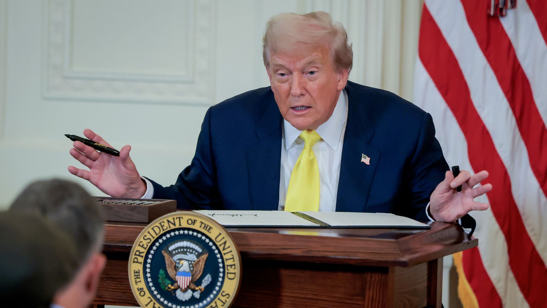 U.S. President Donald Trump gesturse as he signs a National Purple Heart Day Proclamation during an event to honor recipients of the Purple Heart in the East Room of the White House on August 07, 2025 in Washington, DC.