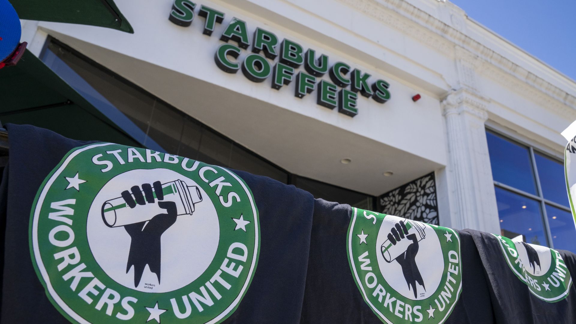 Starbucks Workers United t-shirts hang outside while unionized workers strike.