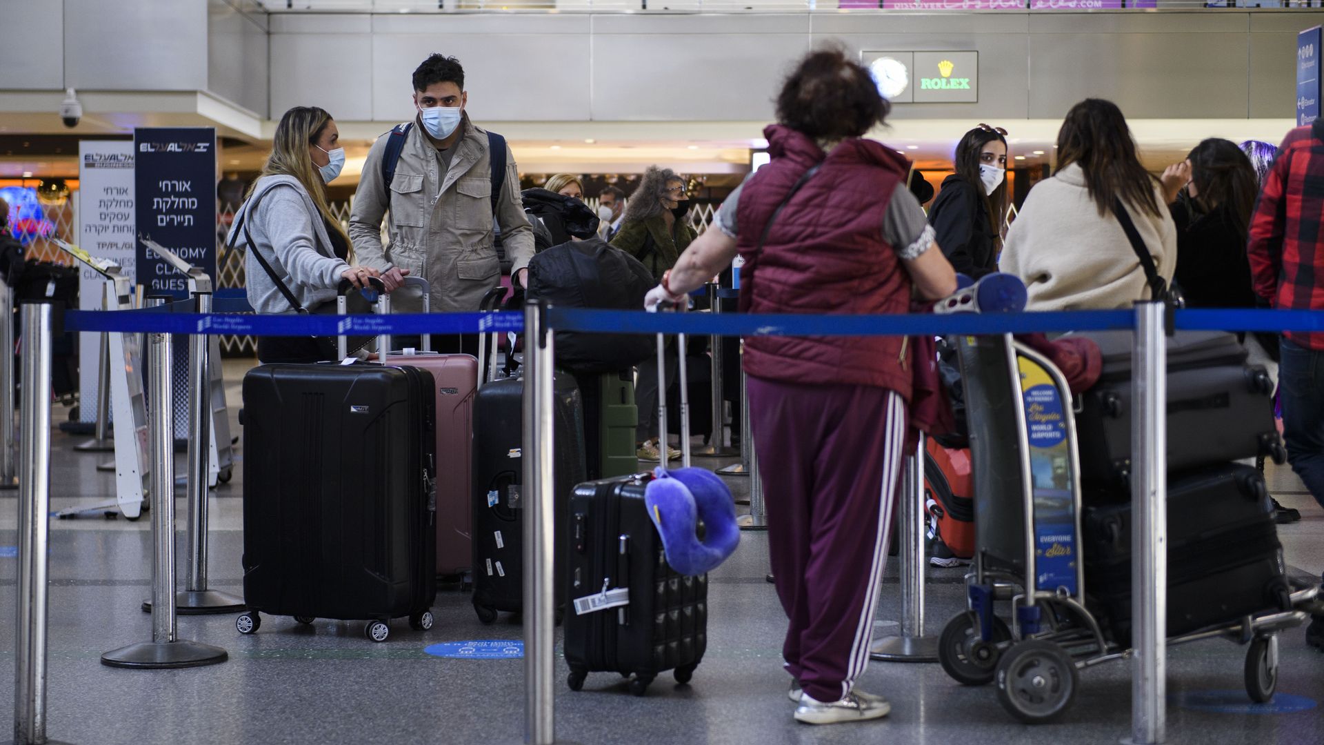Picture of people inside the LAX airport wearing masks while standing in line