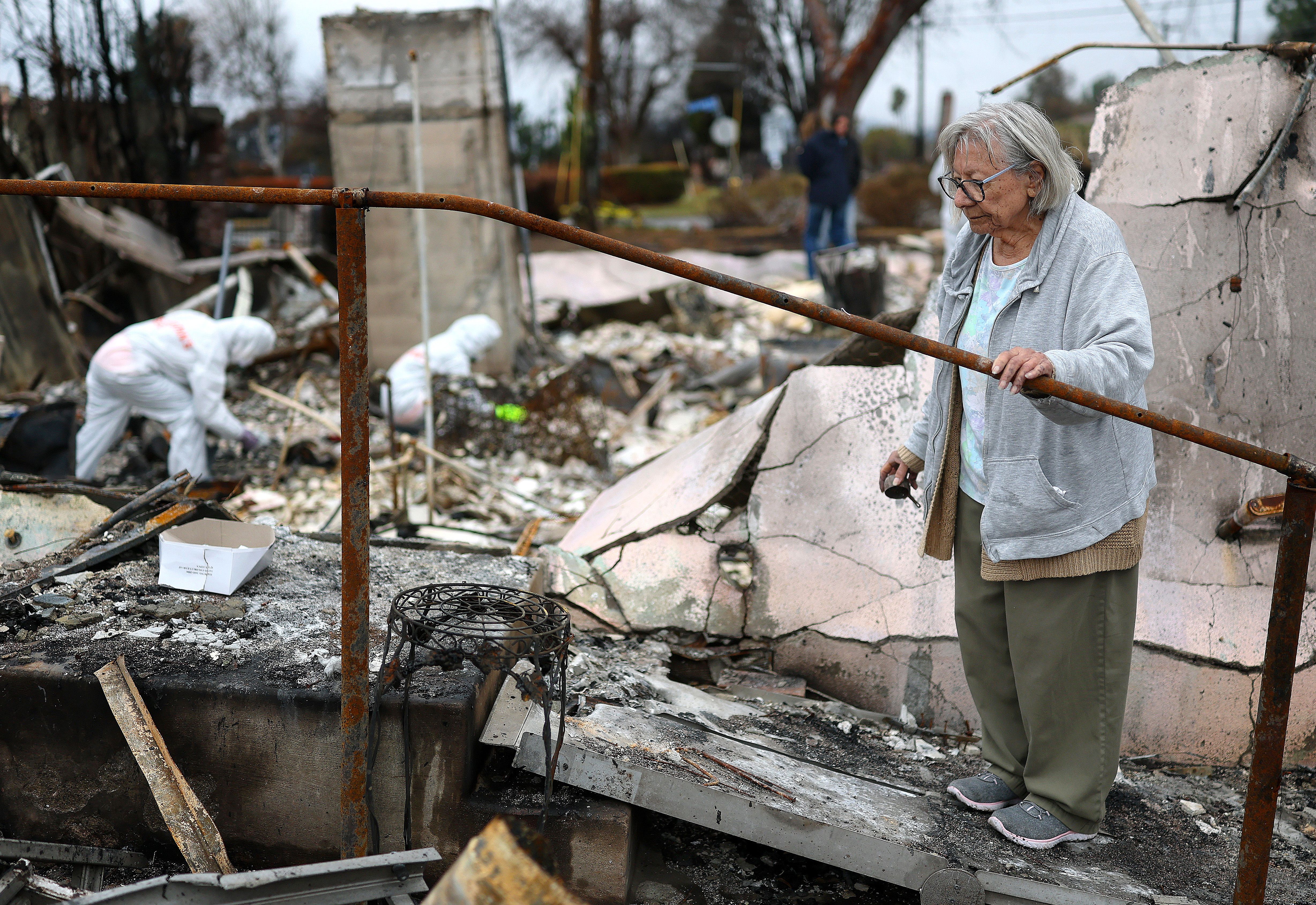Volunteers with Samaritan's Purse help Emma Alvarado (R) search for personal items in the ashes of her family home which burned in the Eaton Fire on February 05, 2025 in Altadena, California. Emma and her husband Manuel had lived in the home since 1972 and their homeowners insurance policy was cance