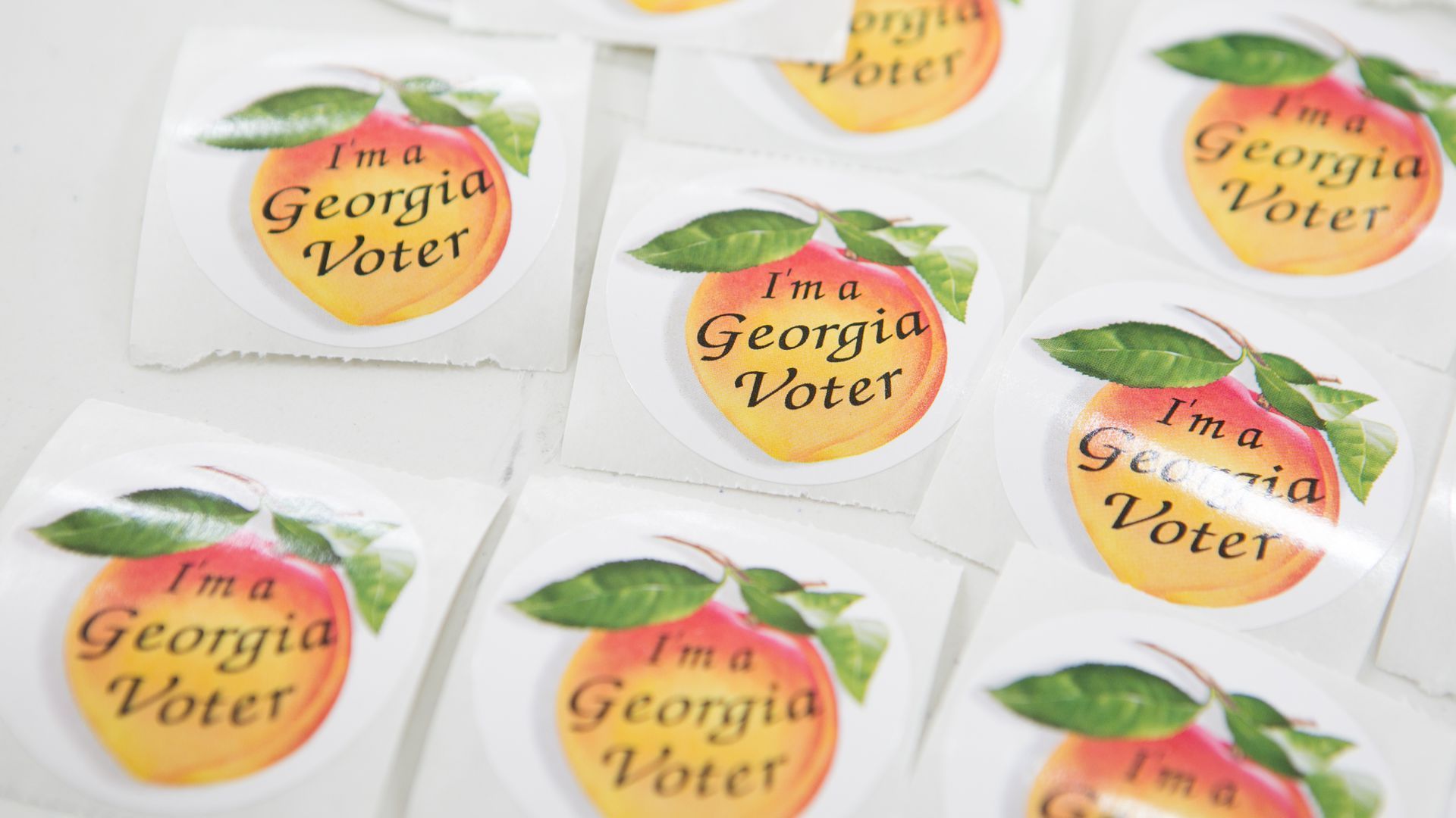 Stickers of a peach, saying "I'm a Georgia voter"