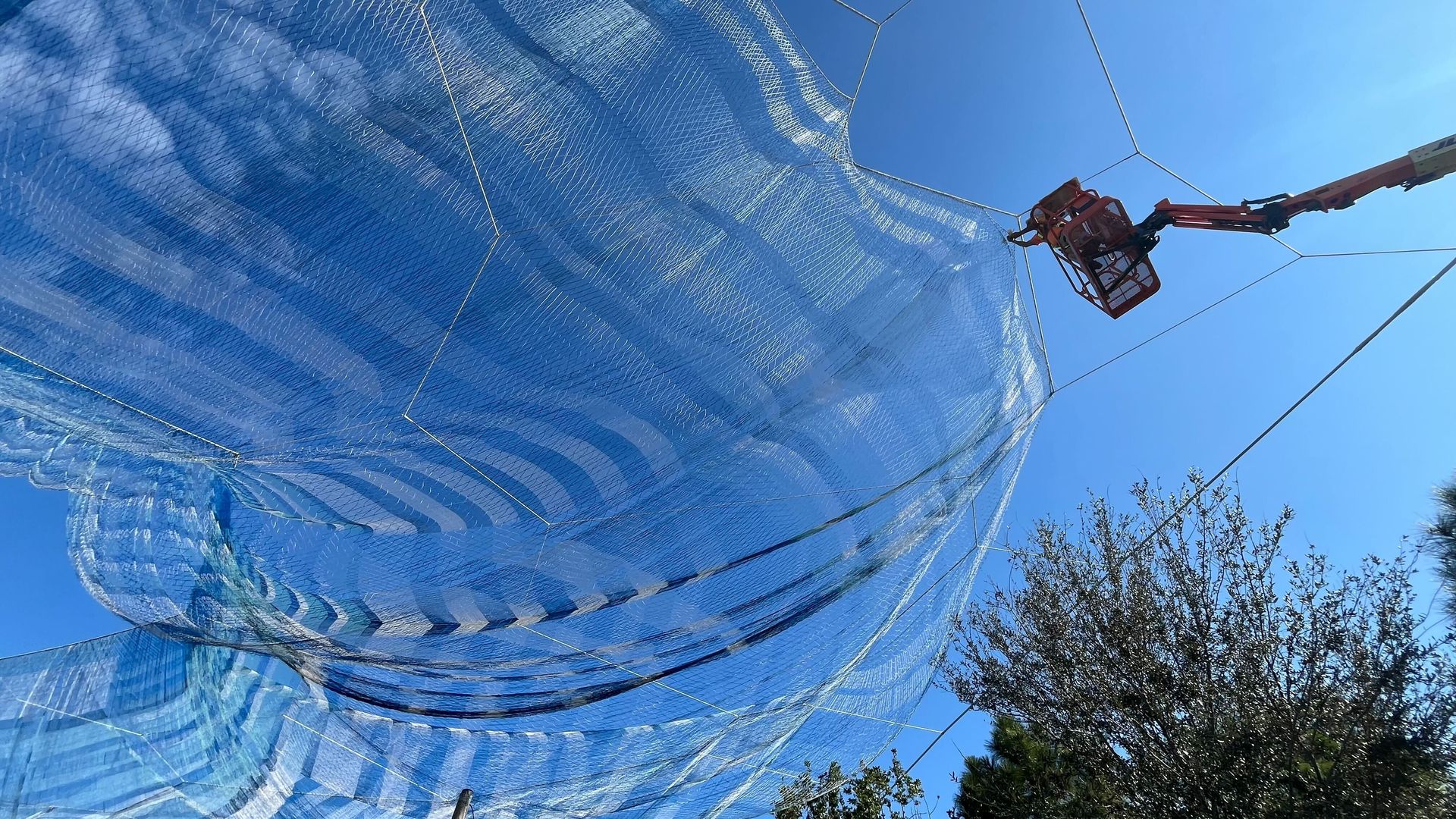 A worker handles Janet Echelman's "Bending Arc" sculpture Monday on the St. Pete Pier.