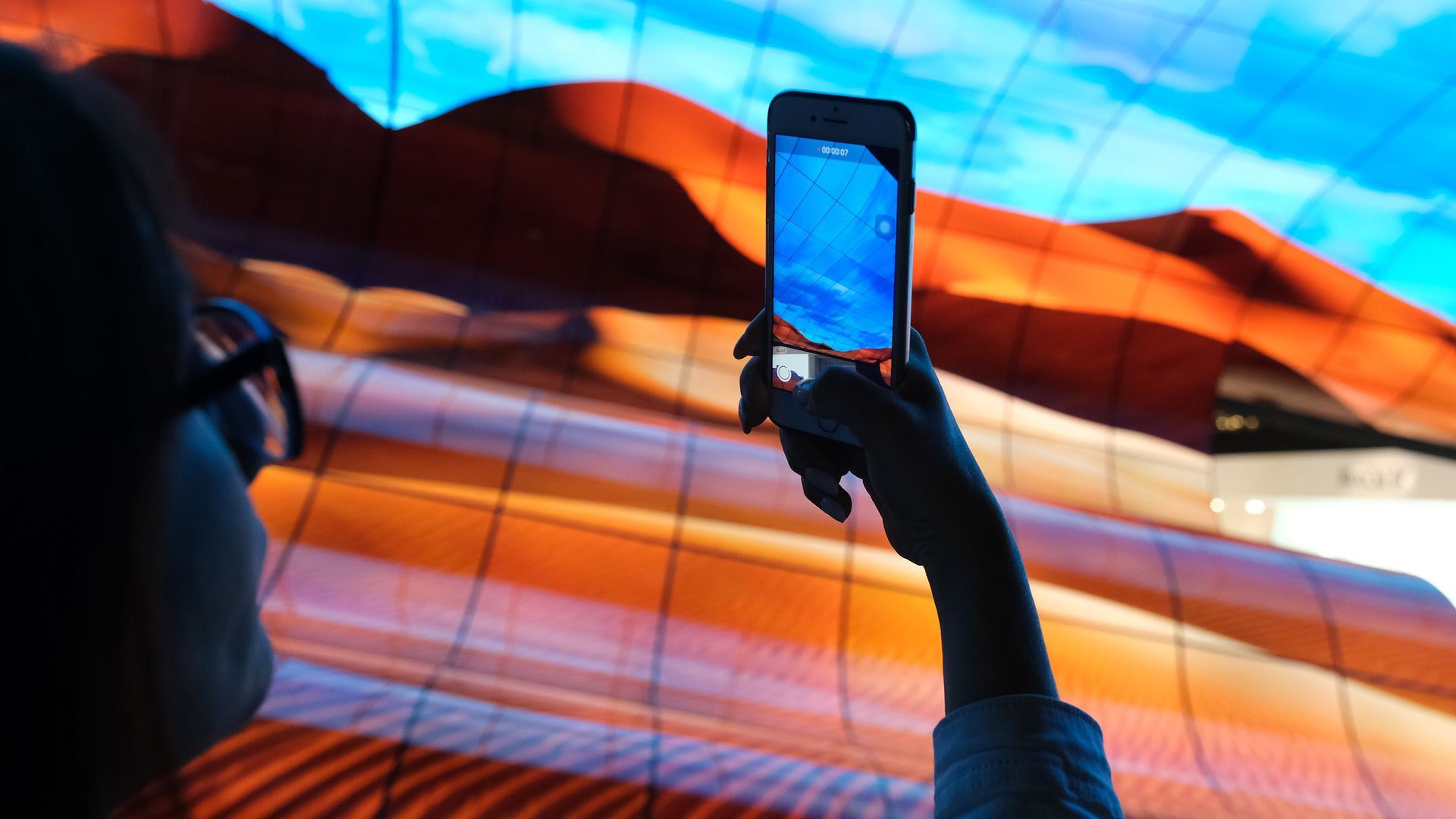 A visitor photographs a display of curved OLED TVs at the LG stand at the 2019 IFA home electronics and appliances trade fair. Photo: Sean Gallup/Getty Images