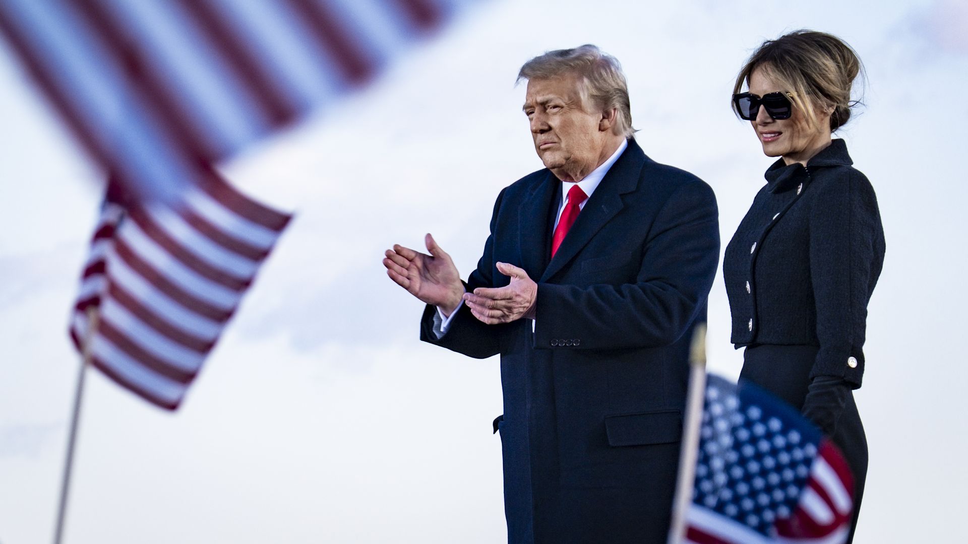 President Donald Trump and First Lady Melania Trump on stage after speaking to supporters at Joint Base Andrews before boarding Air Force One for his last time as President on January 20