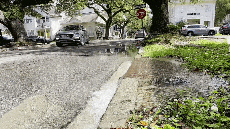 Image shows water coming out of a pipe into the street.