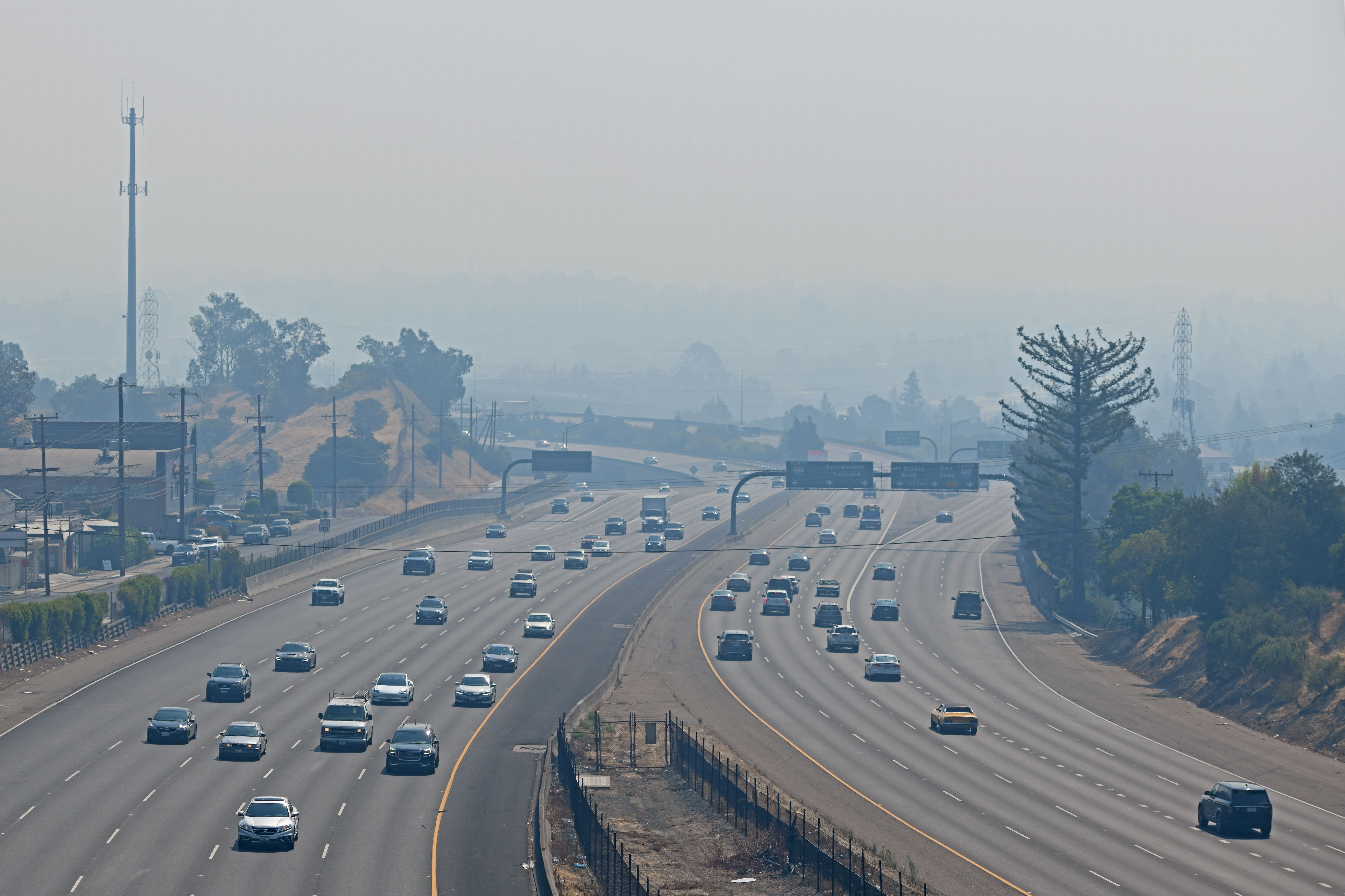 Traffic on Highway 24 as motorist travel through a thick cloud of smoke in Walnut Creek, Calif., on Saturday, Aug. 22