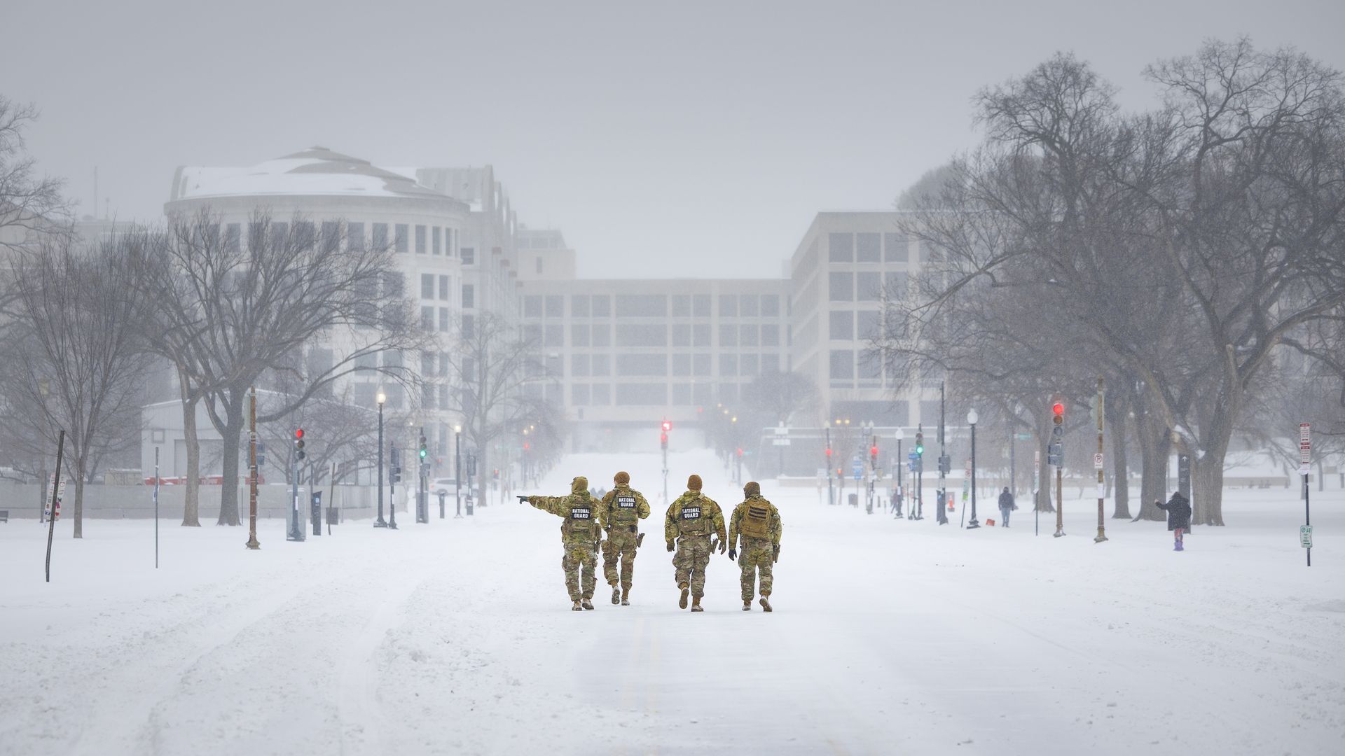National Guard troops walk down a snow-covered street in downtown D.C.