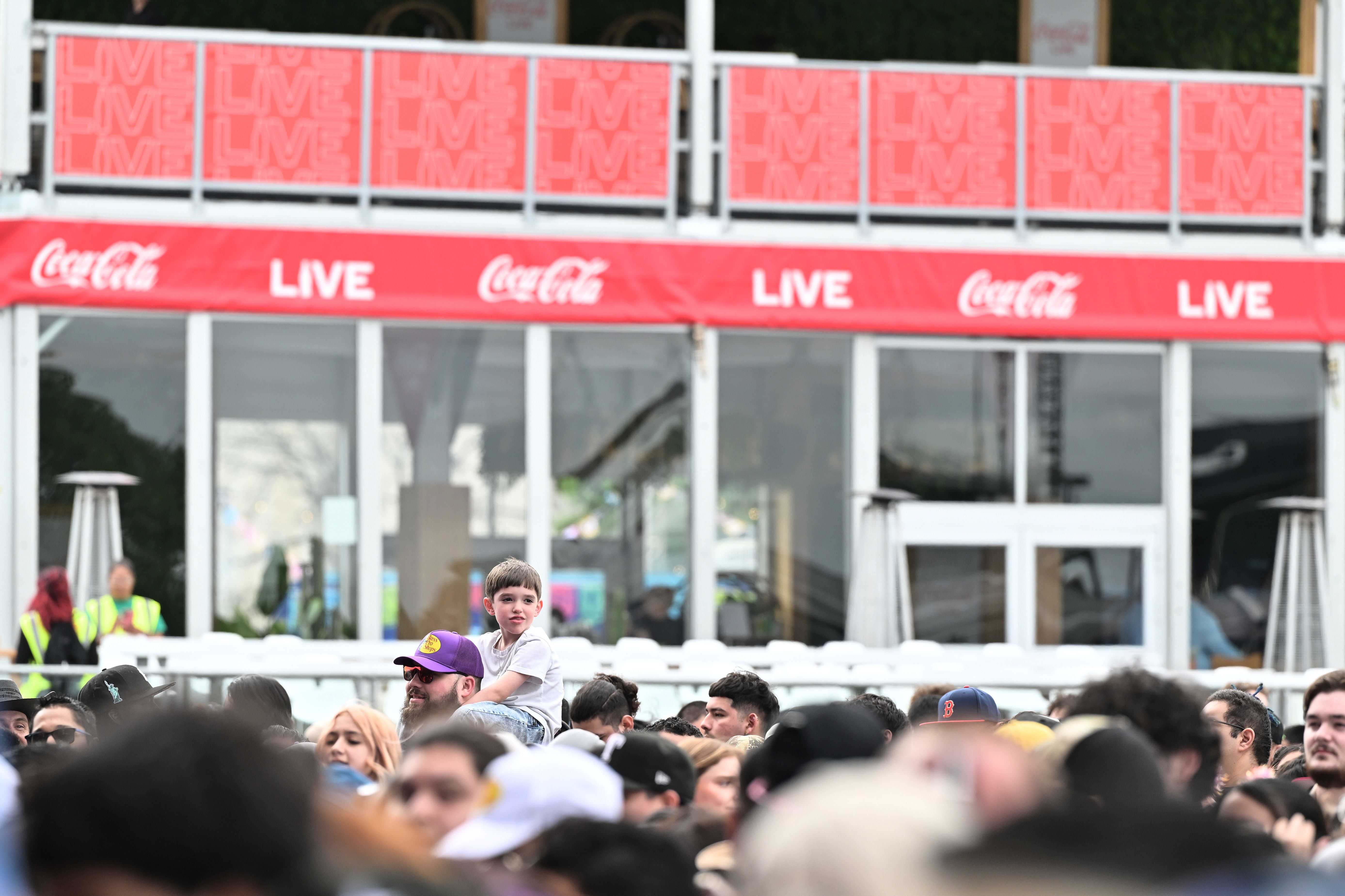 A child is seen on a man's shoulders at the music festival.
