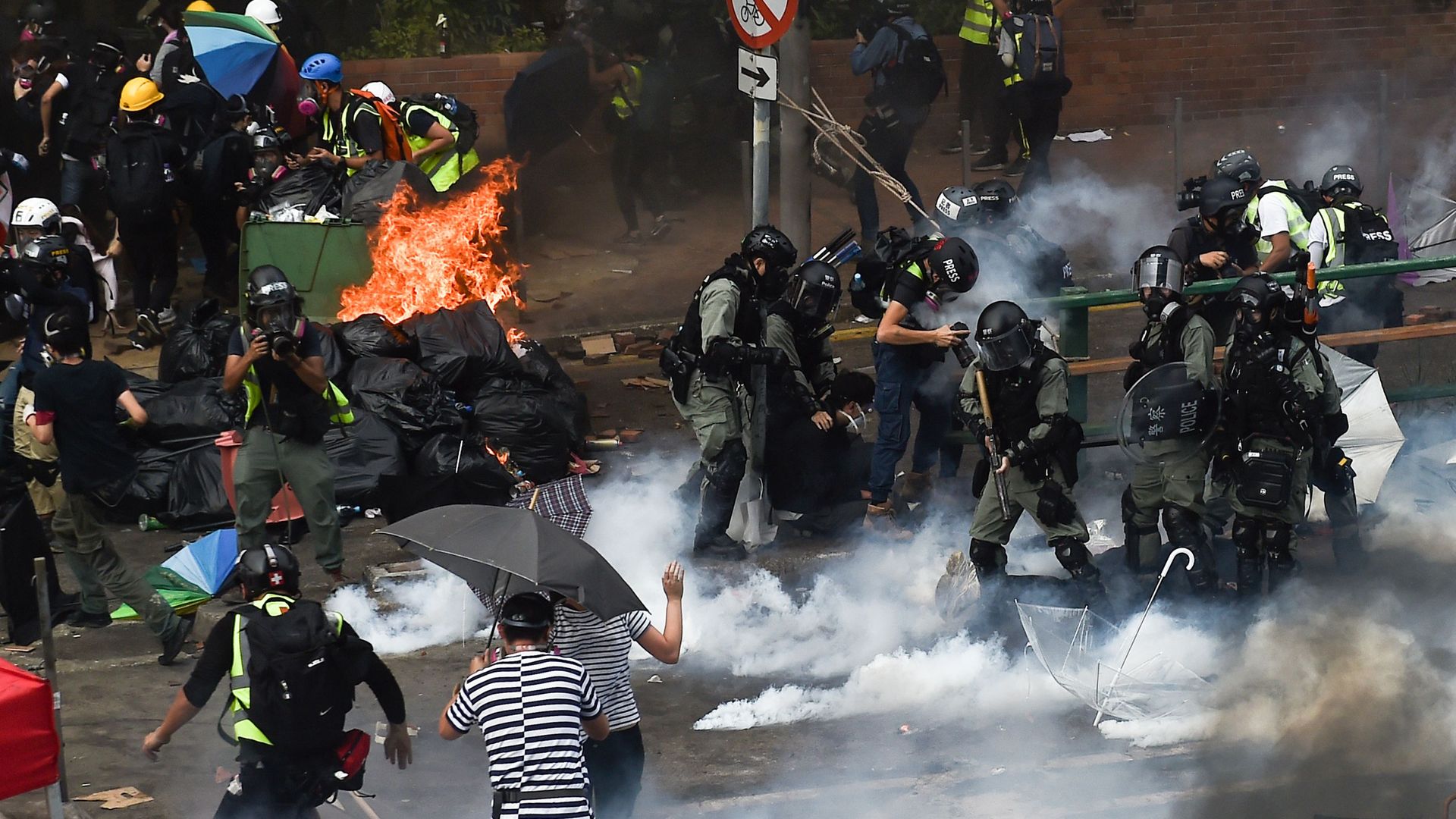 Riot police (R) make arrests as protesters (L) attempt to find safe passage out of the Hong Kong Polytechnic University campus in Hung Hom district of Hong Kong
