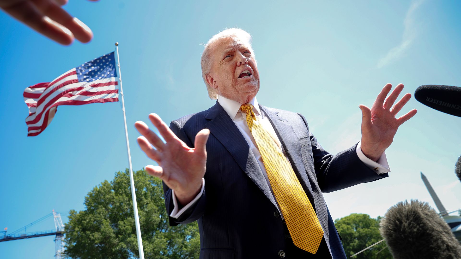 President Trump speaks to reporters in front of an American flag before departing the White House for a trip to China on May 12, 2026, in Washington, D.C.
