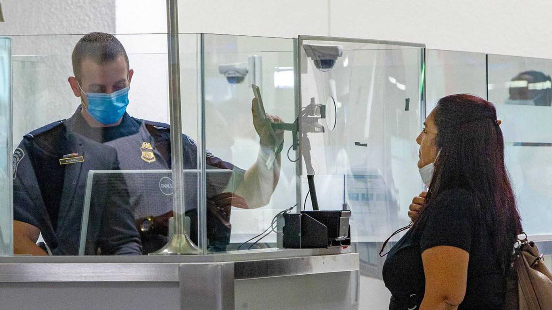 A U.S. Customs and Border Protection officer on Nov. 20, 2020, checks a passenger arriving on an international flight using facial-recognition technology to automate the manual document checks required for admission into the United States.