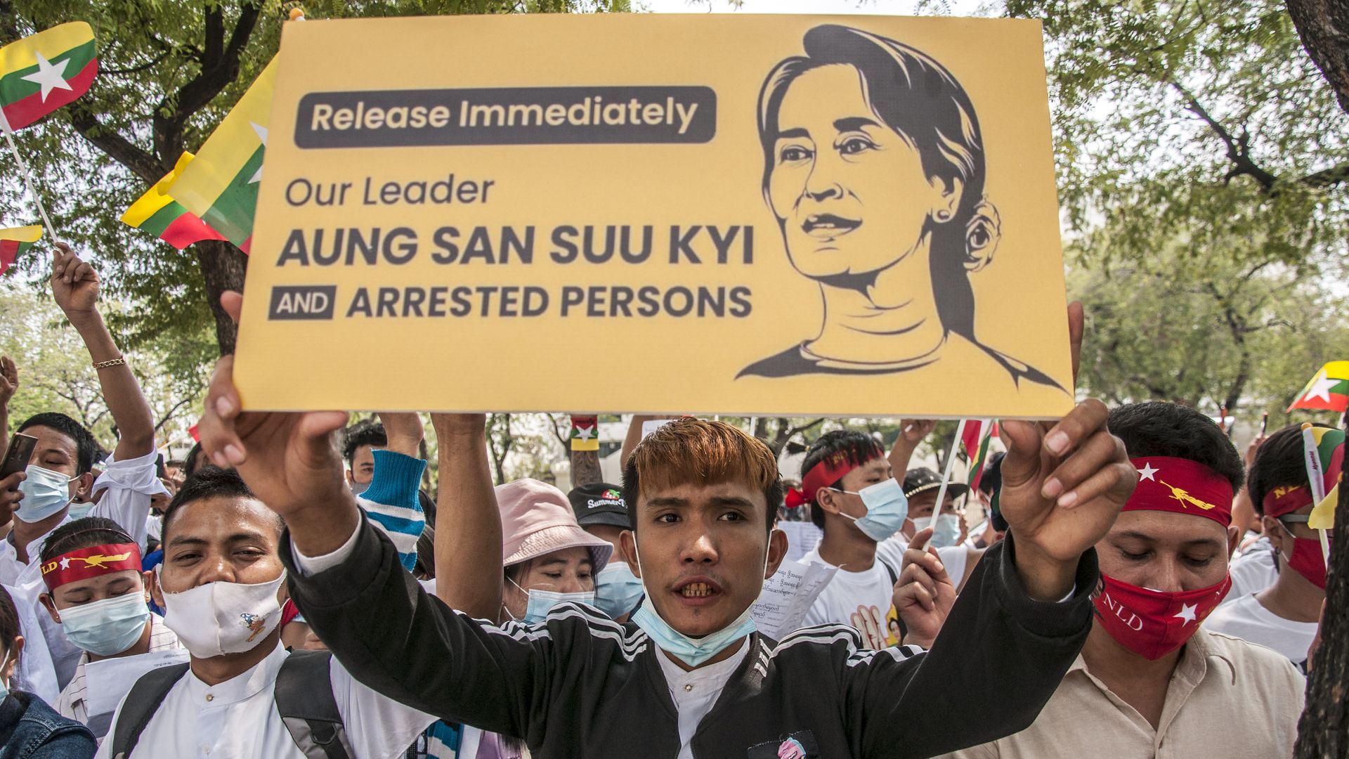 Picture of a protester holding a placard with a portrait of Aung San Suu Kyi during a demonstration