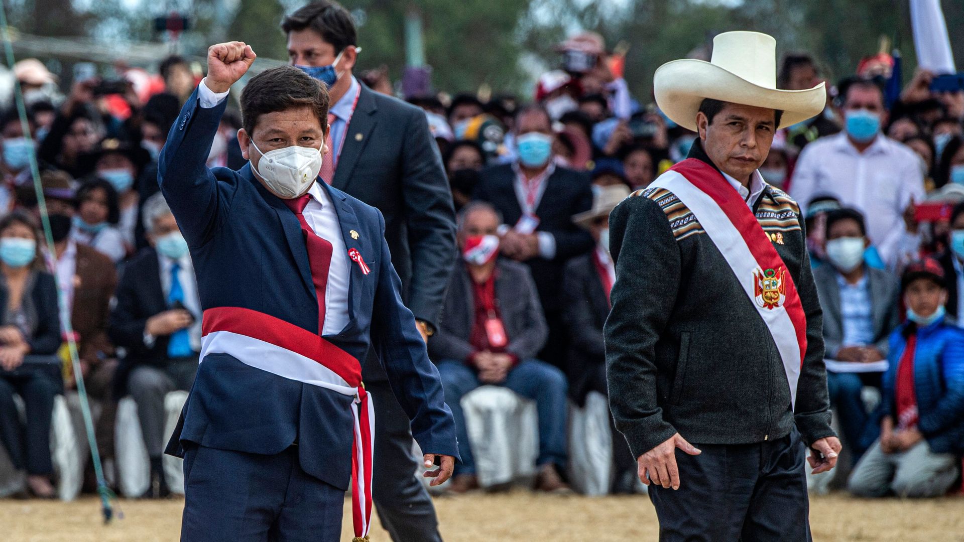 Peru's new prime minister Guido Bellido (L) raises his fist as he walks next to President Pedro Castillo (R) in Ayacucho., southern Peru.