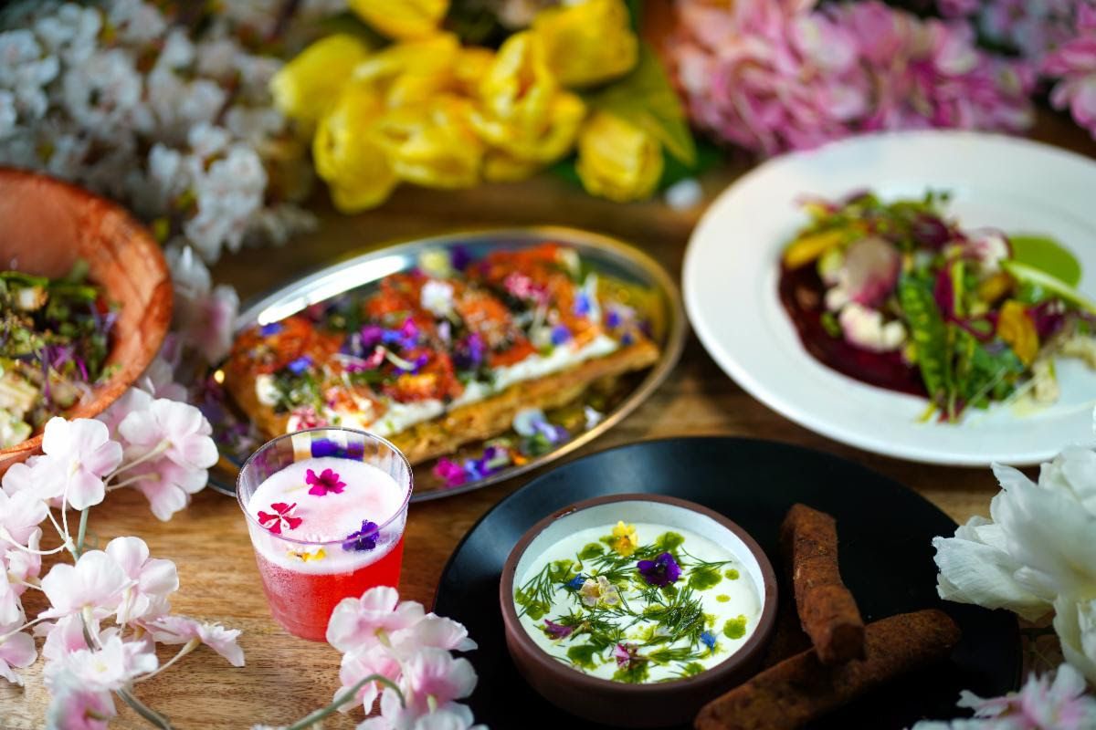 A table with floral accent foods and drinks including a pink cocktail