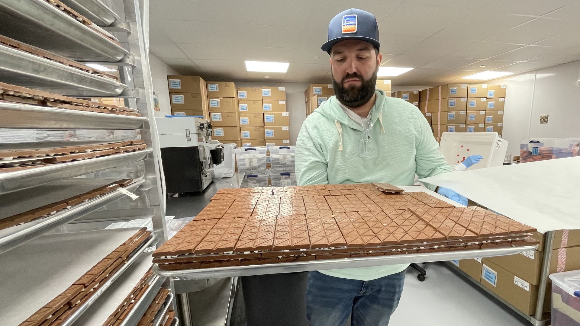 Co-owner Brian Cusnick holds out a large tray full of cannabis-infused s'mores chocolate bars in the Coast Cannabis facility.