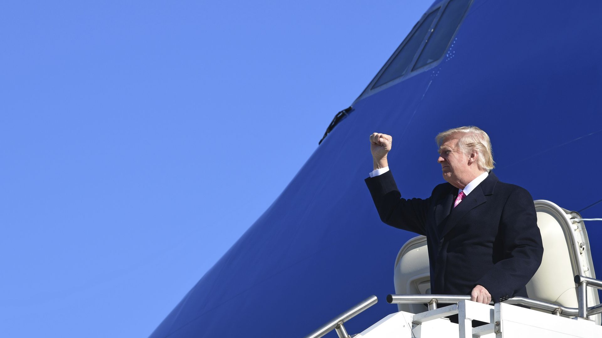President Donald Trump gestures as he walks down the steps of Air Force One.