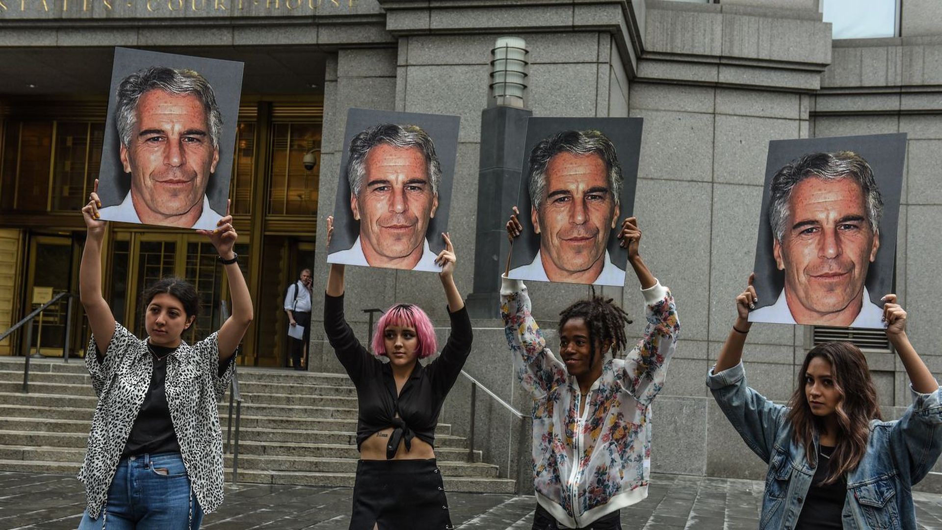 Protesters hold placards of convicted sex offender Jeffrey Epstein.