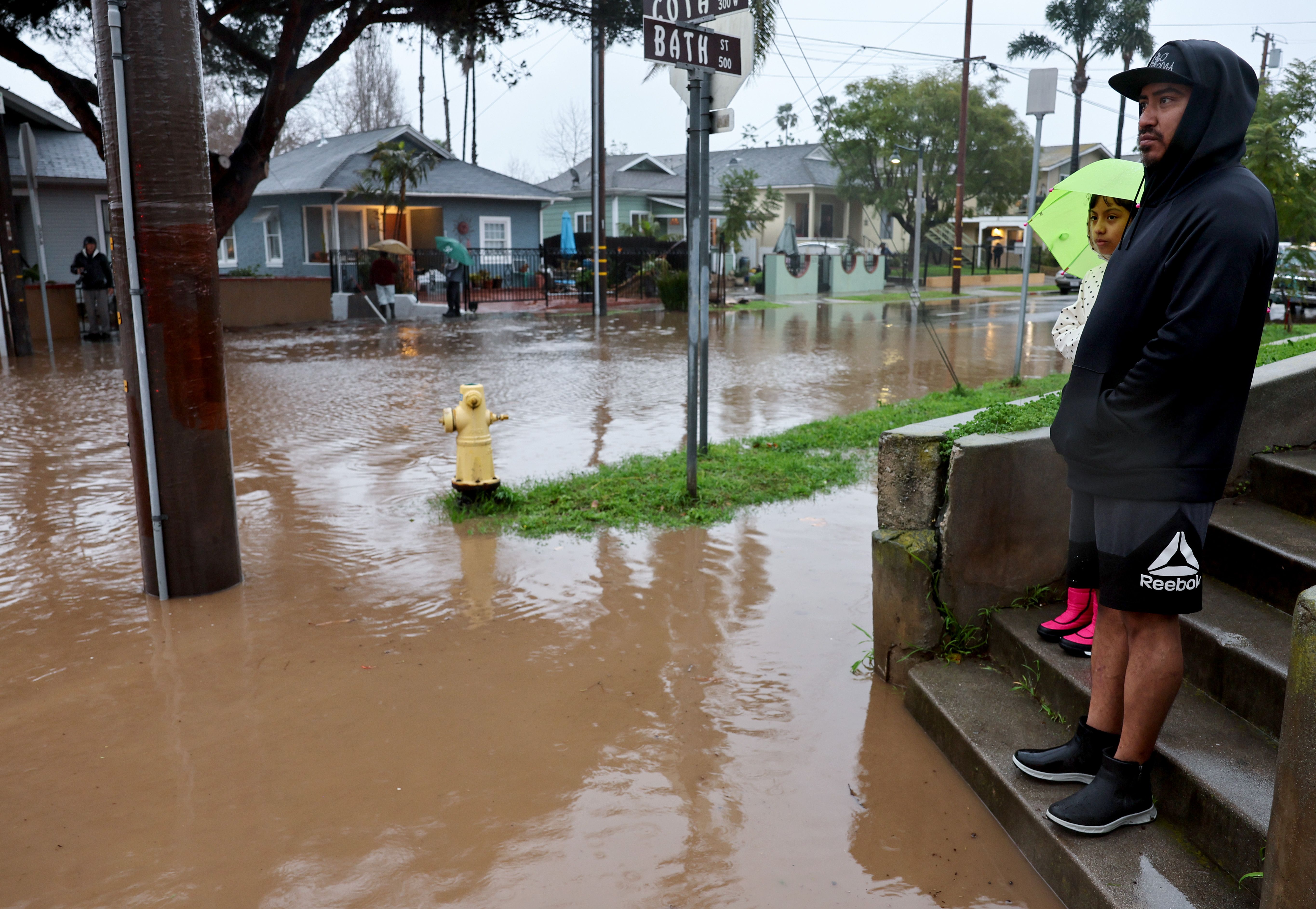  Residents stand along a flooded street as a powerful long-duration atmospheric river storm, the second in less than a week, impacts California on February 4, 2024 in Santa Barbara, California. The storm is delivering potential for widespread flooding, landslides and power outages while dropping heavy rain and snow across the region.