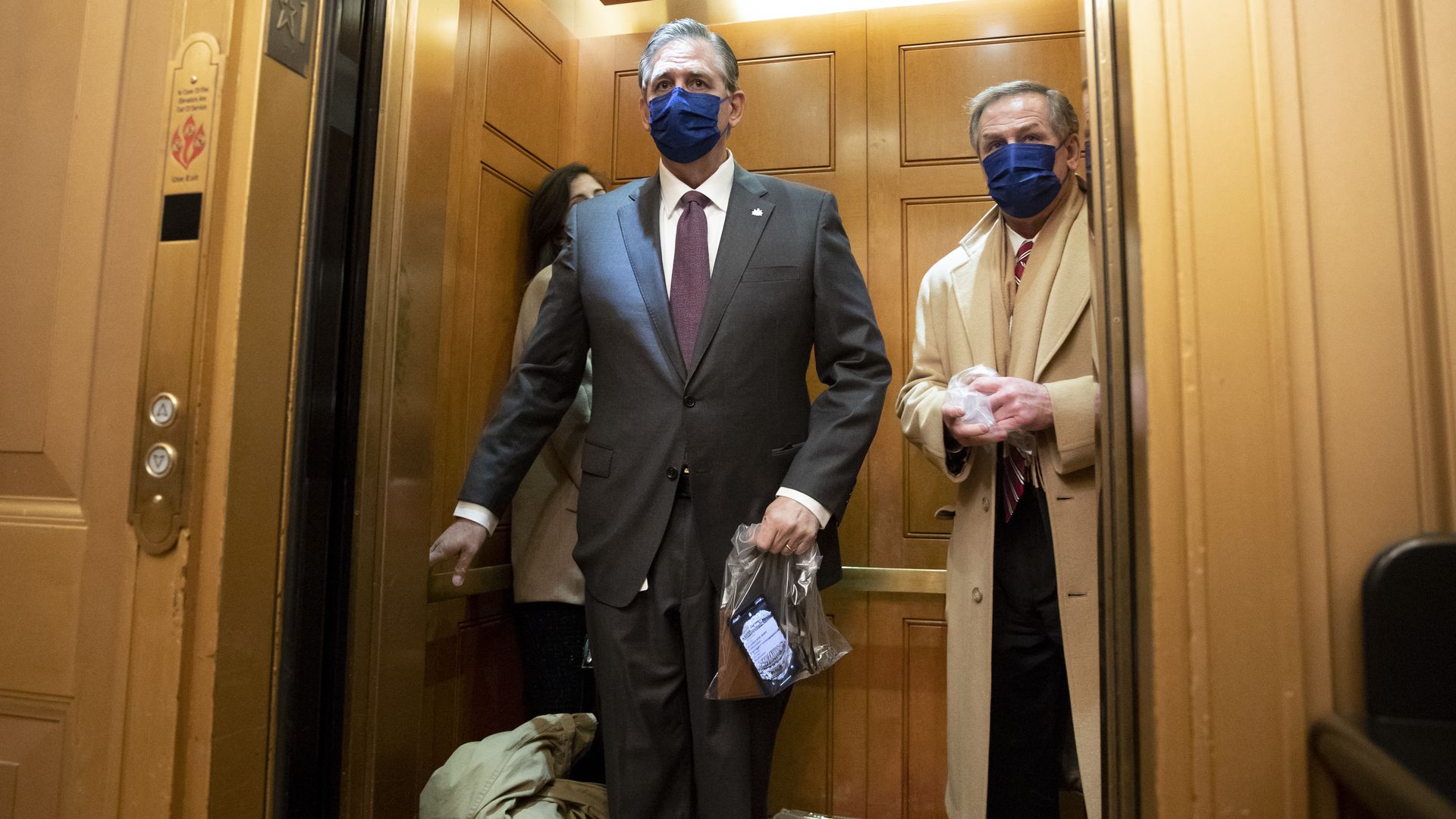 Members of former President Trump's impeachment defense team is seen on a Senate elevator.