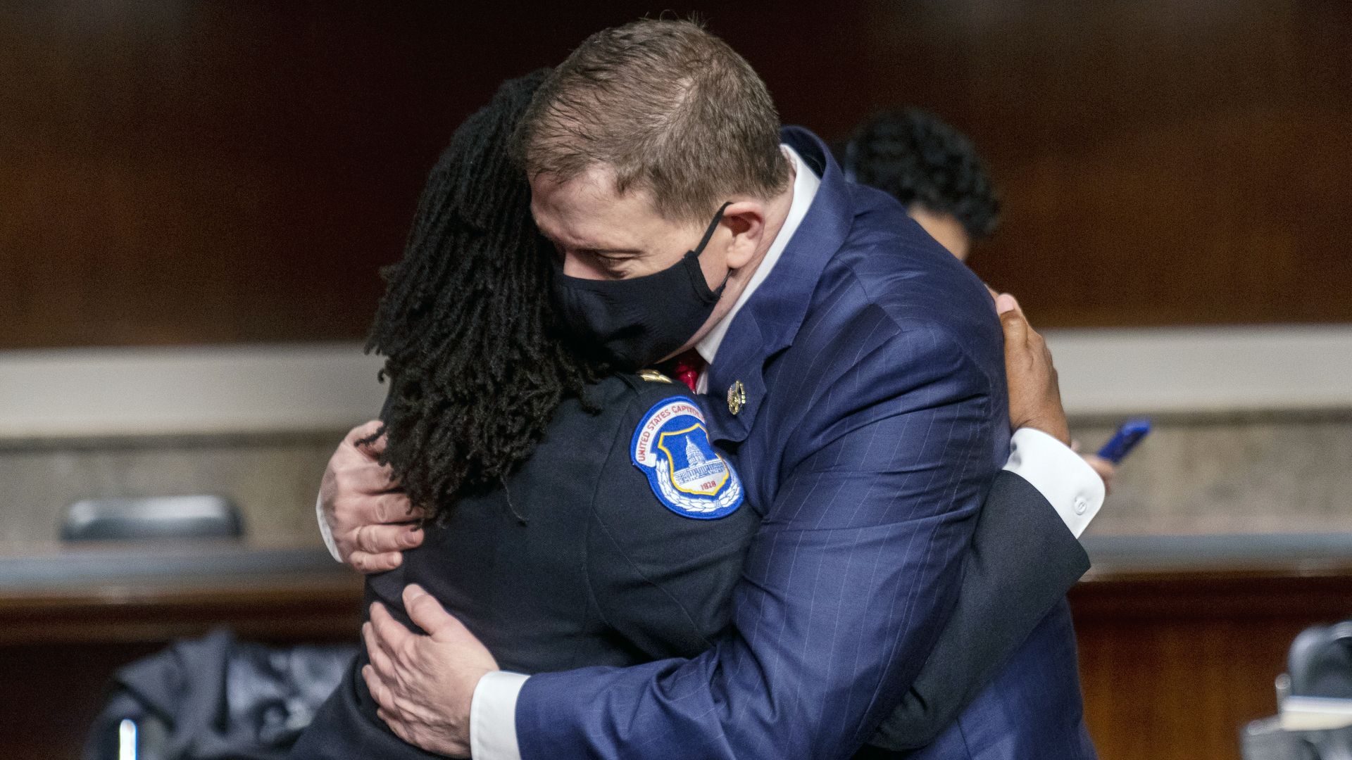 Steven Sund, former Capitol chief of police, right, hugs Carneysha Mendoza, captain of the U.S. Capitol Police Department