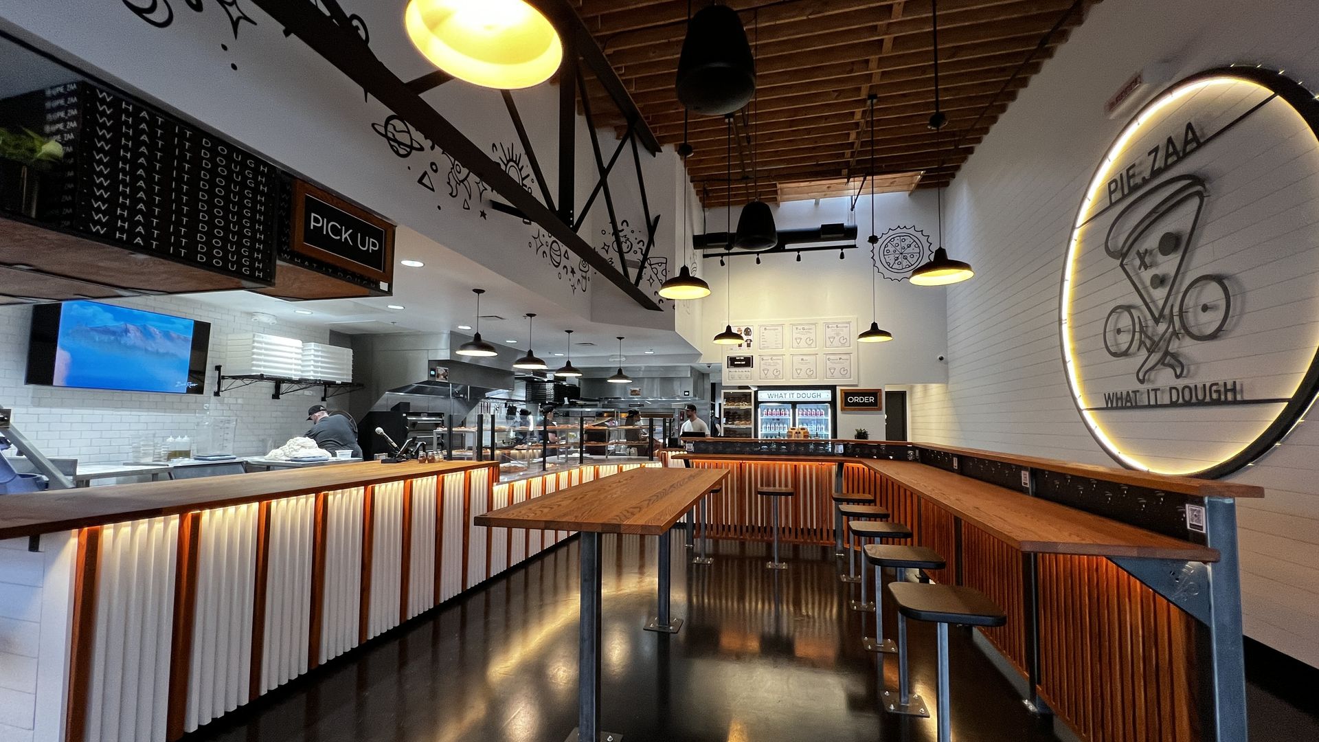 inside pizza shop with large sign that reads Pie.Zaa