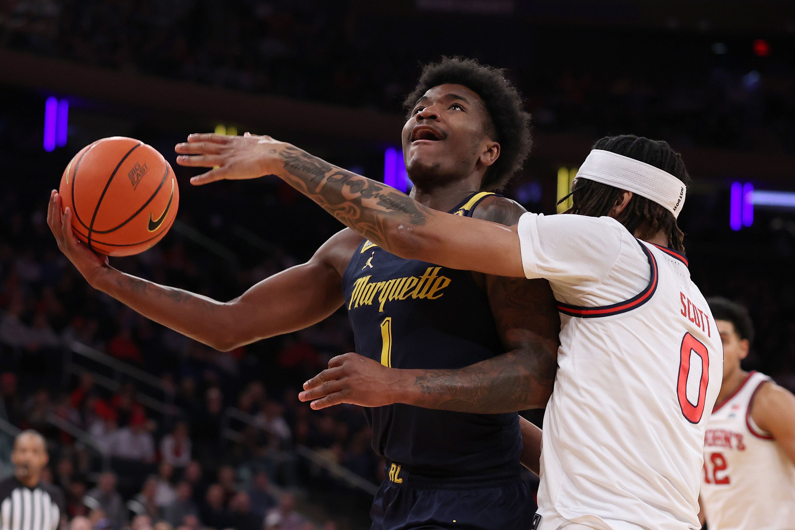 A basketball player tries to block a shot. 