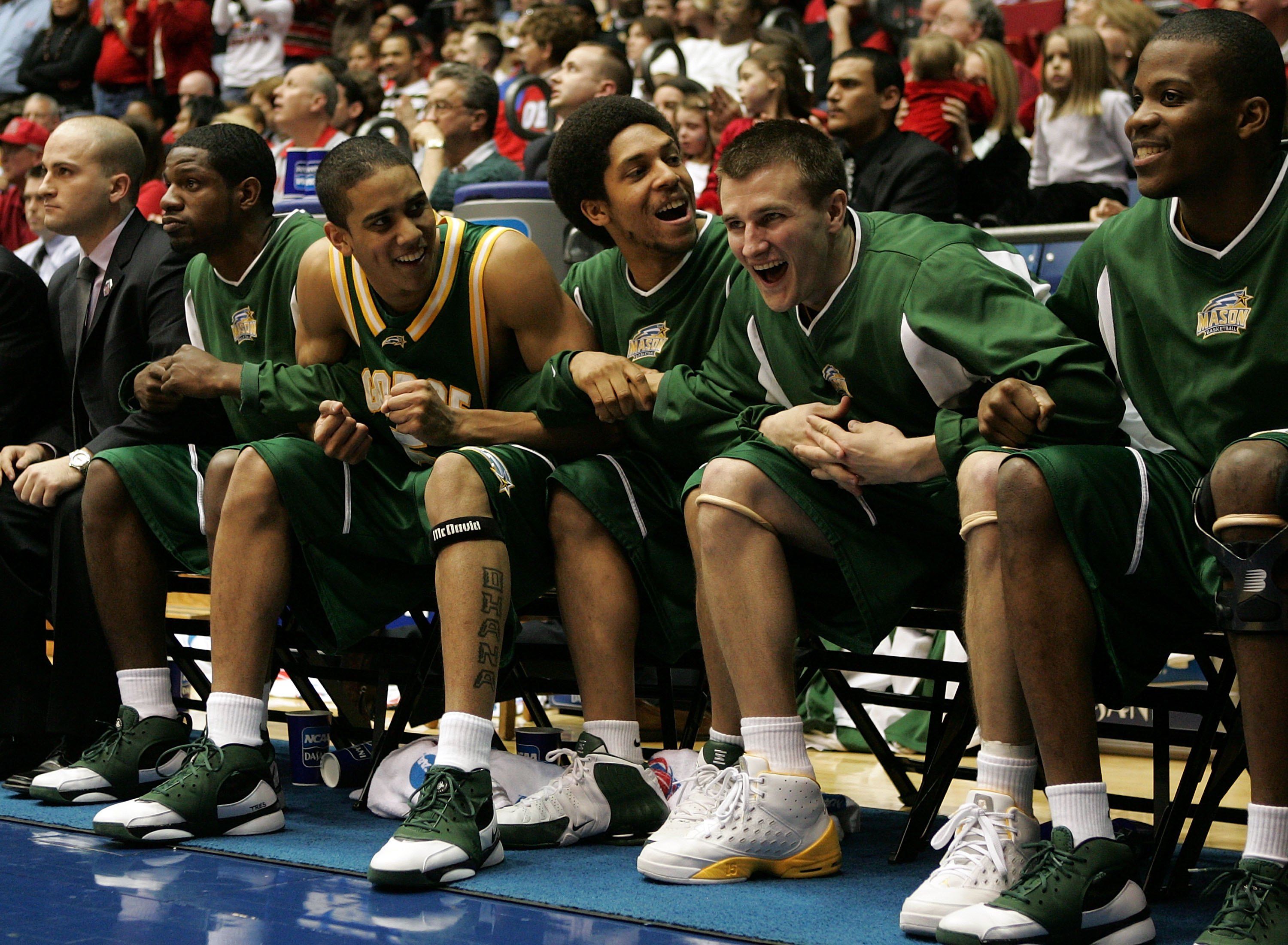 George Mason basketball players celebrate on the bench.