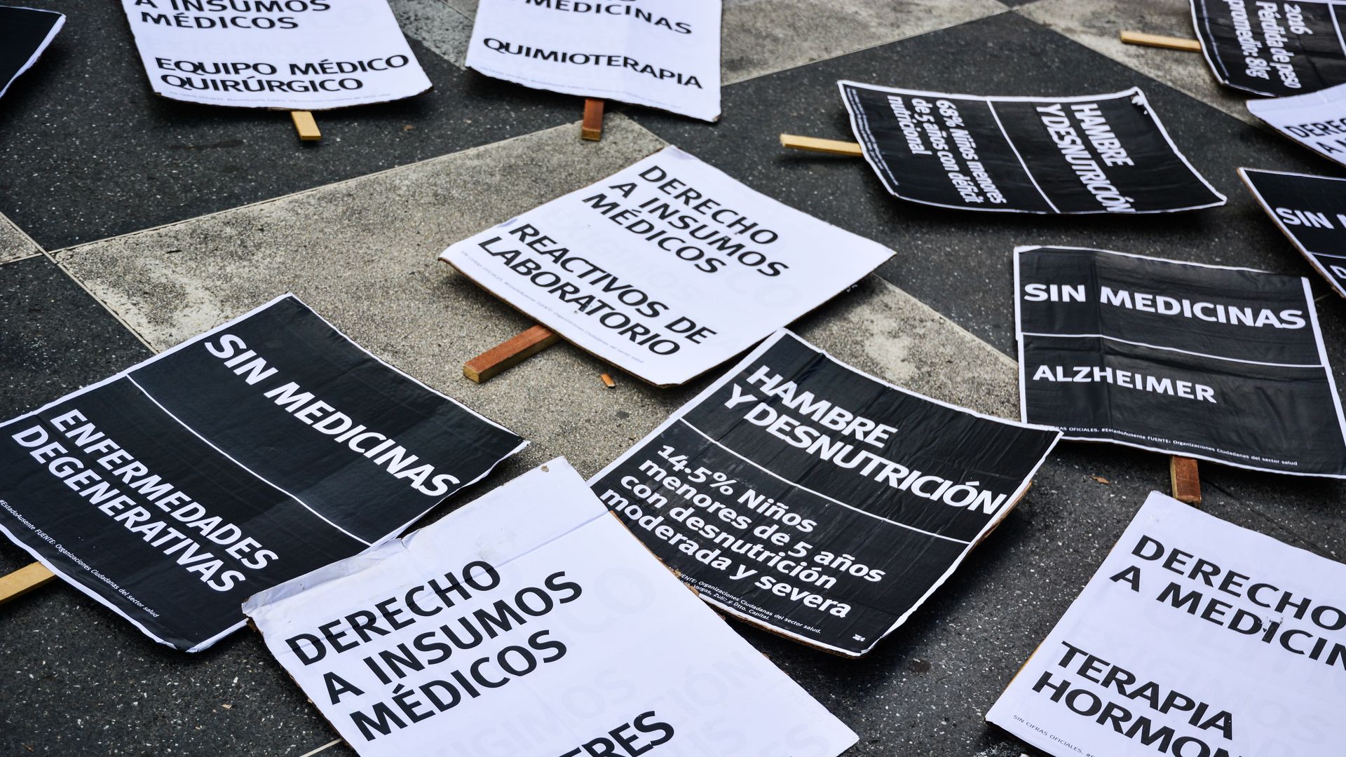 Protest signs in Caracas, Venezuela, where a drug shortage has exacerbated a malaria outbreak.