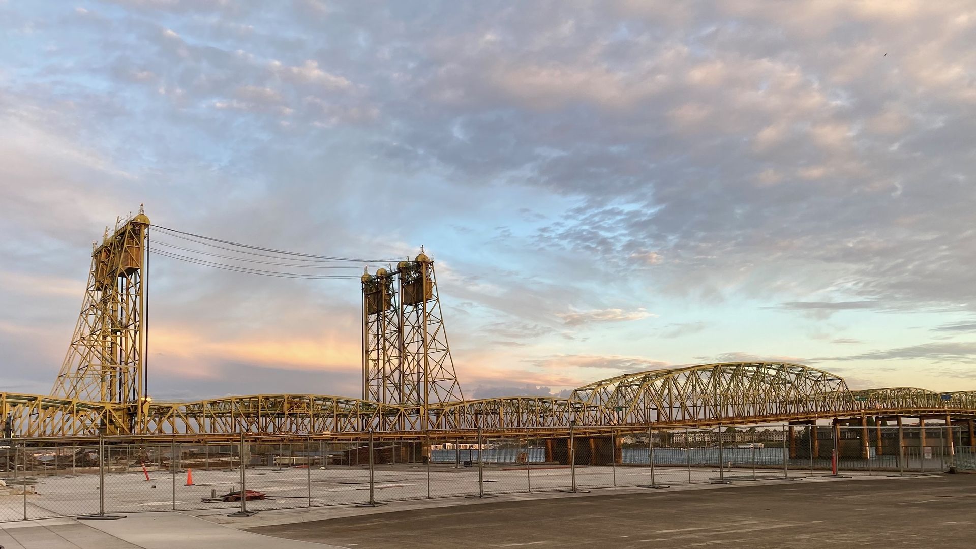 A bridge with two lift towers against a dramatic sky.