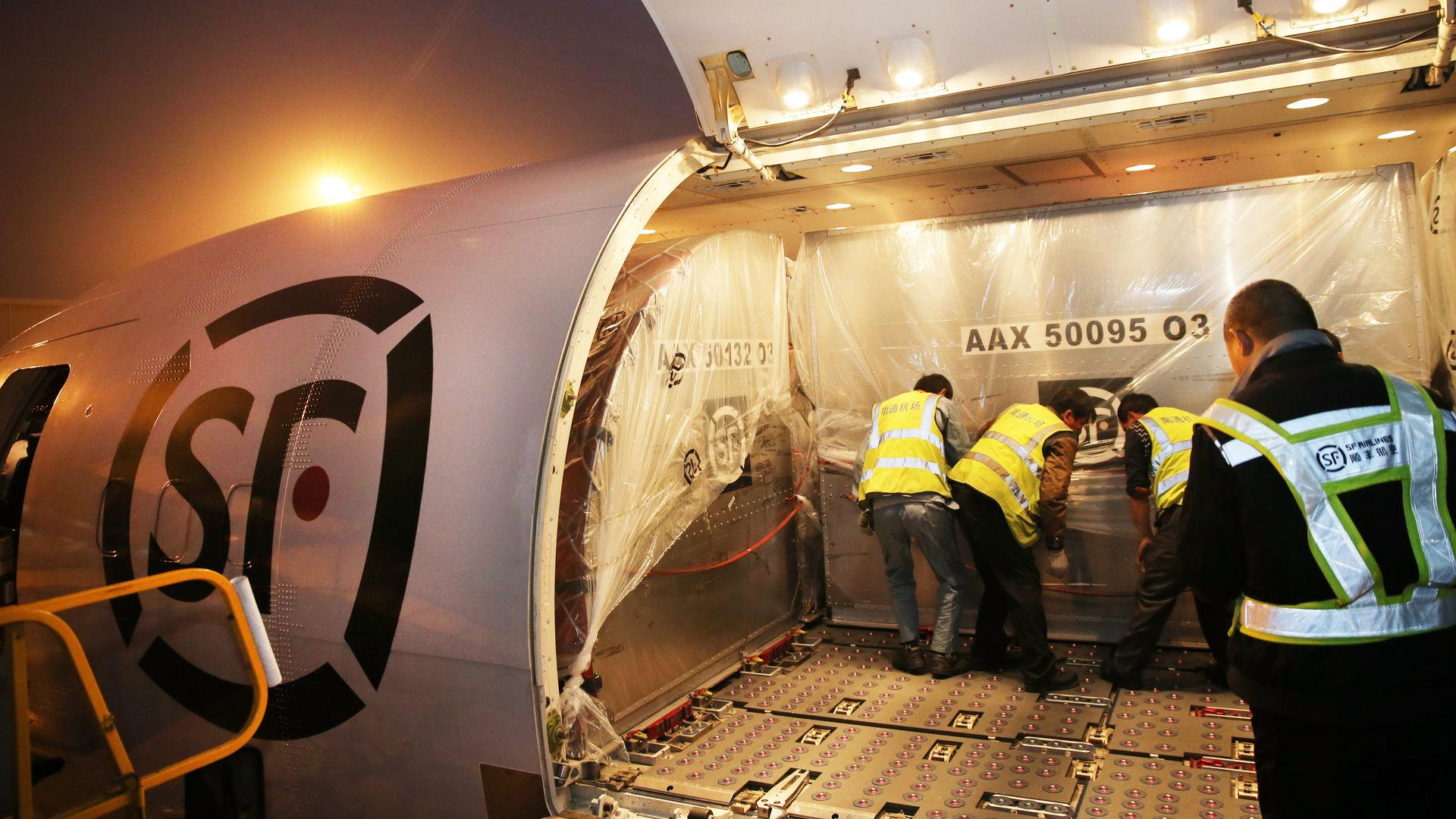 Crews help load parcels for delivery on SF airlines