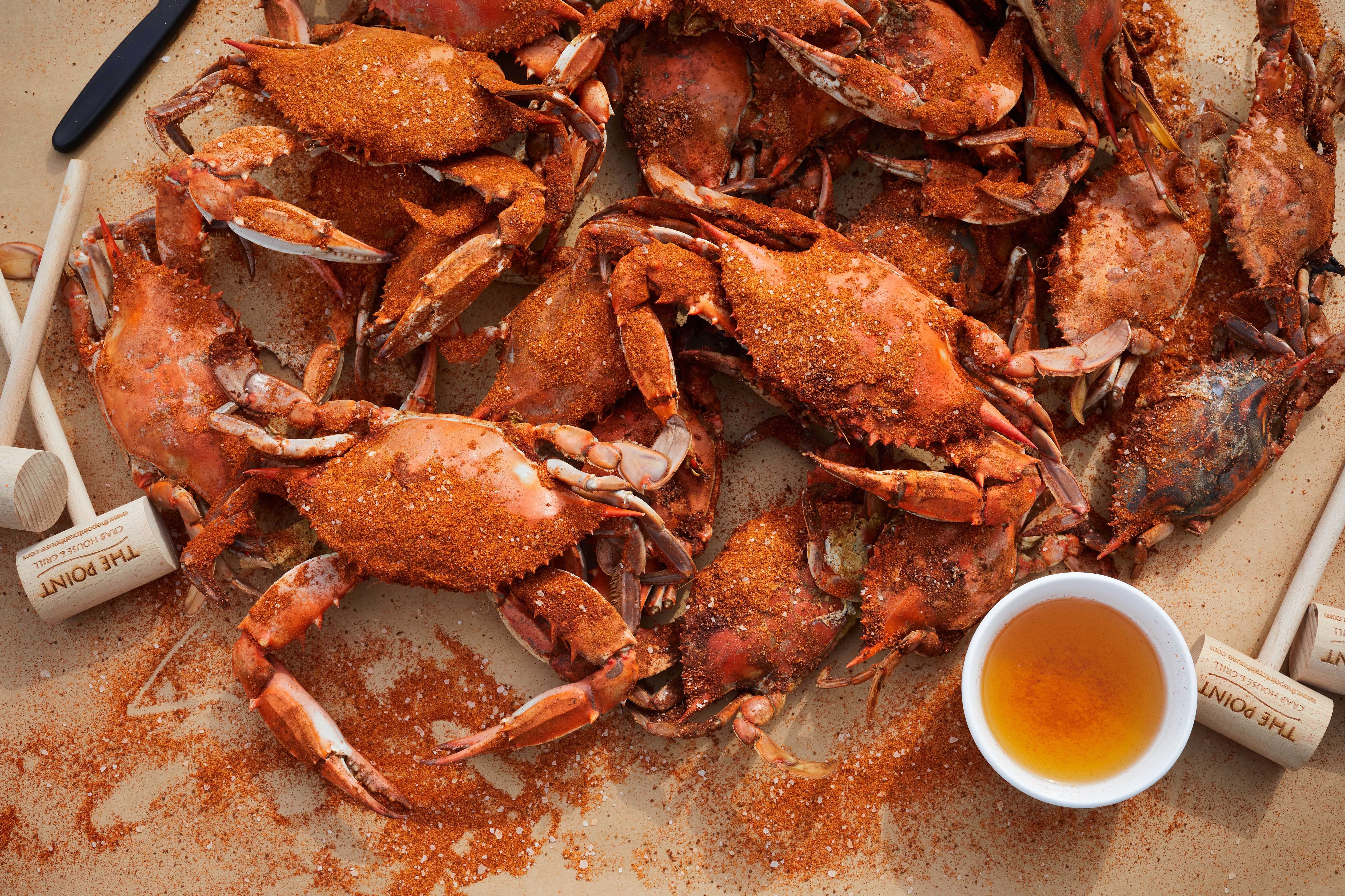Steamed blue crabs with spice and mallets on brown paper