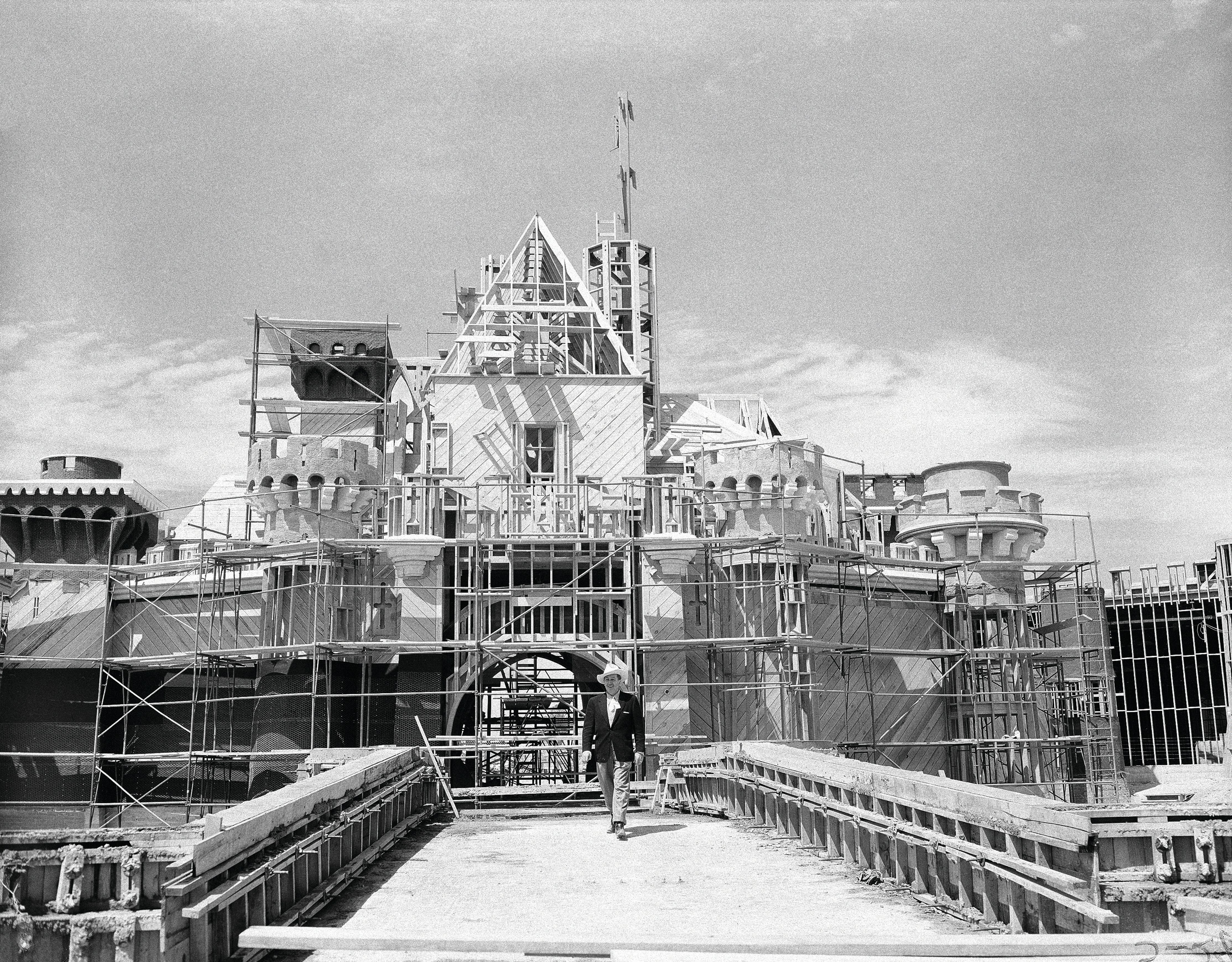 FILE - Walt Disney crosses the drawbridge that serves as the entrance to Sleeping Beauty Castle at Disneyland, in Anaheim, Calif., on April 16, 1955. (AP Photo/David F. Smith, File)