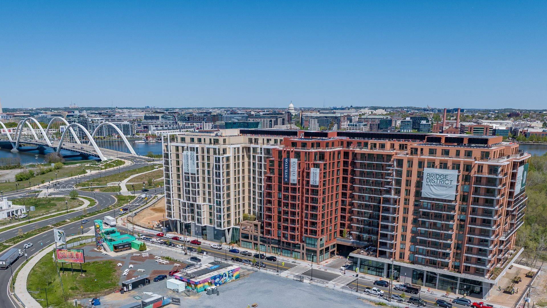 A photo showing an aerial view of apartment buildings with a bridge and river in the background.