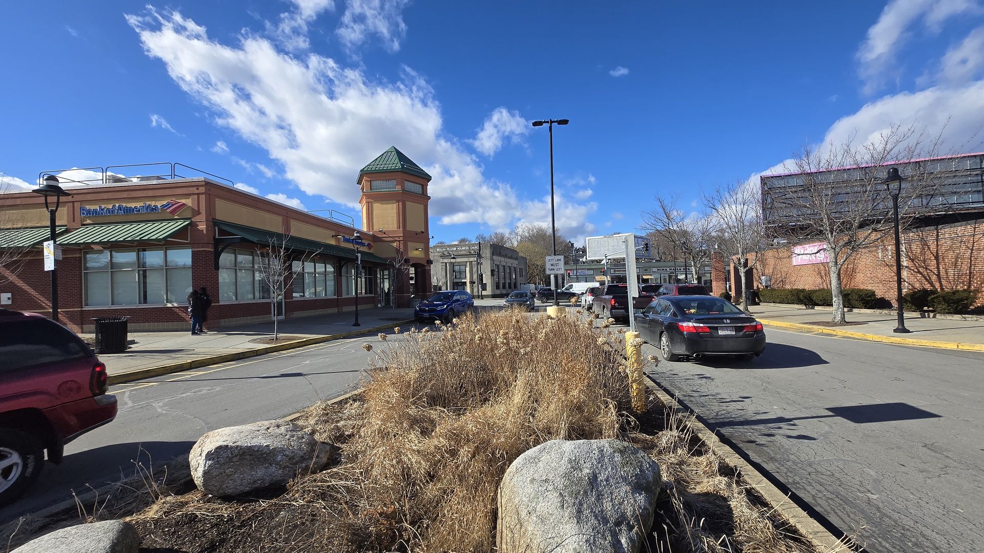 A shot of Grove Hall shopping mall on the left, from the median separating different lanes. 