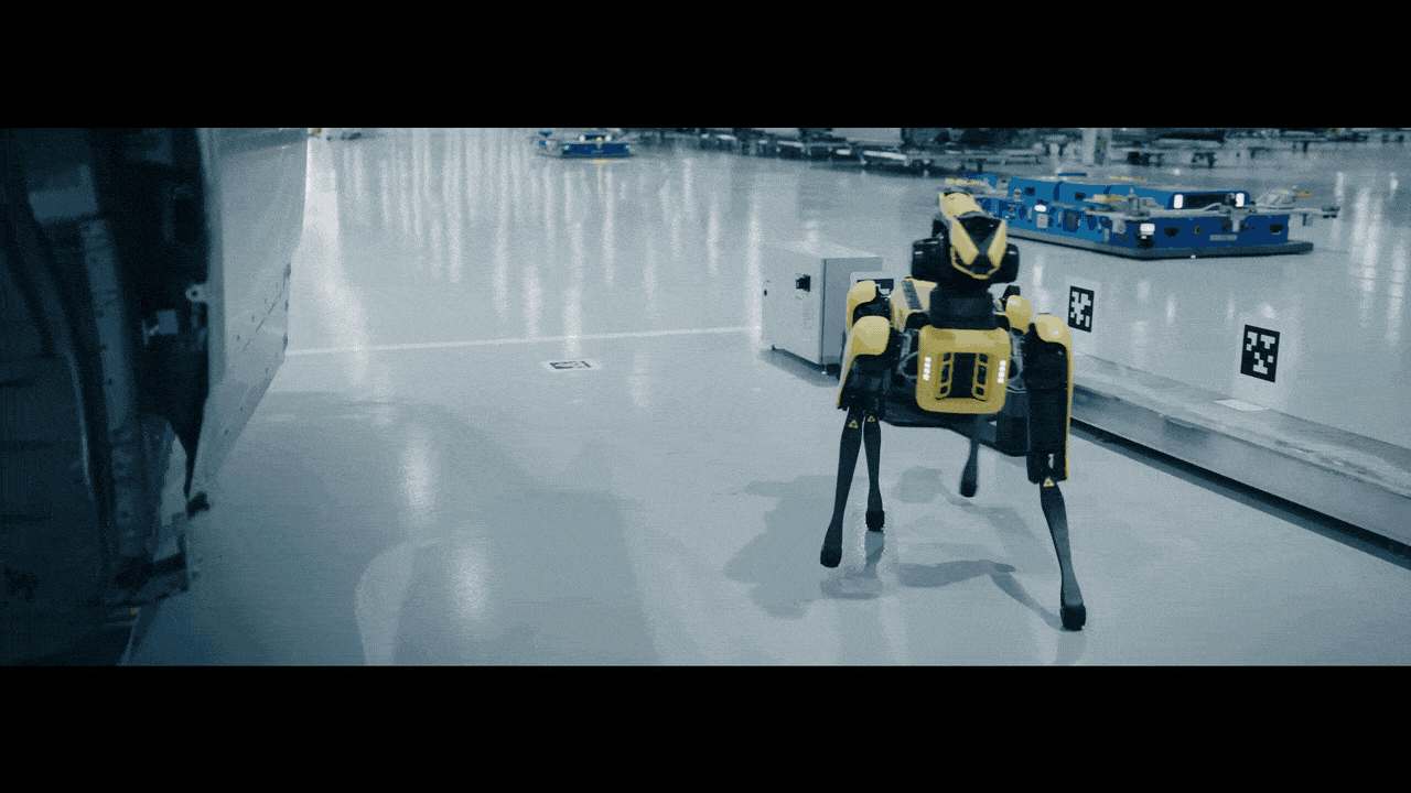 short video clip of Boston Dynamics' four-legged Spot robots using sensors to inspect the exterior of an incomplete car. 
