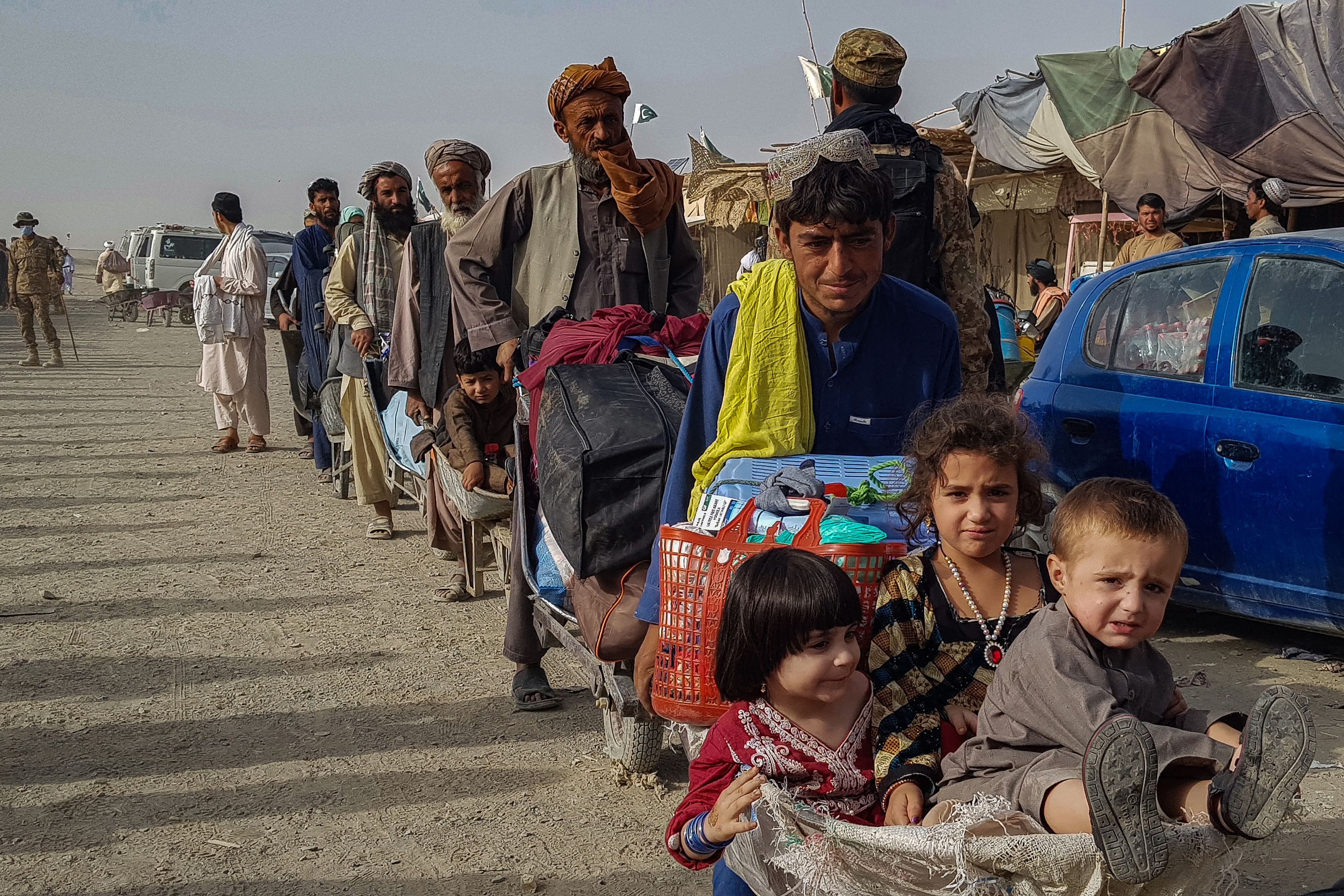  Afghan nationals queue up at the Pakistan-Afghanistan border crossing point in Chaman on August 17