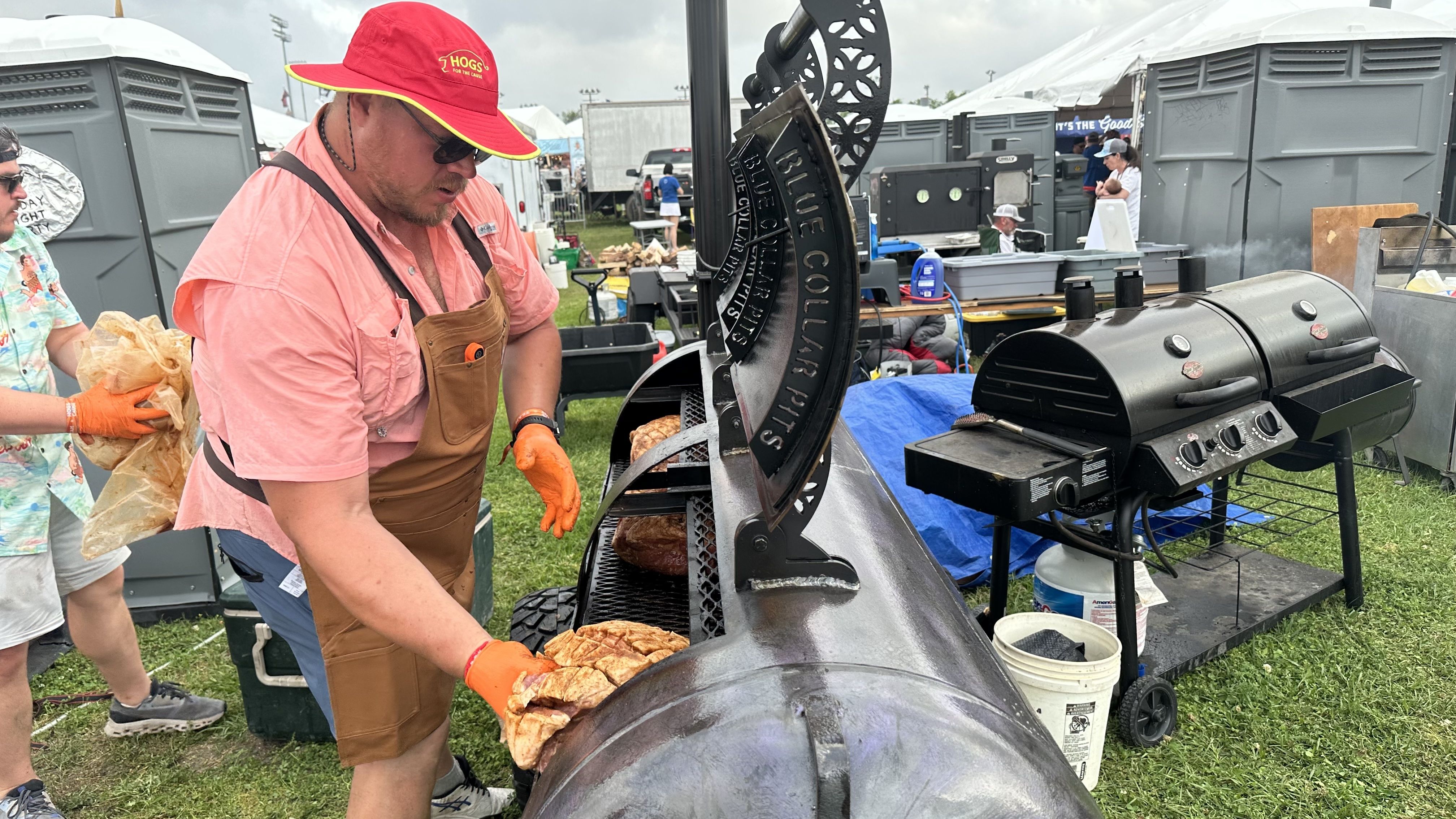 Photo shows a man putting pork on the grill.