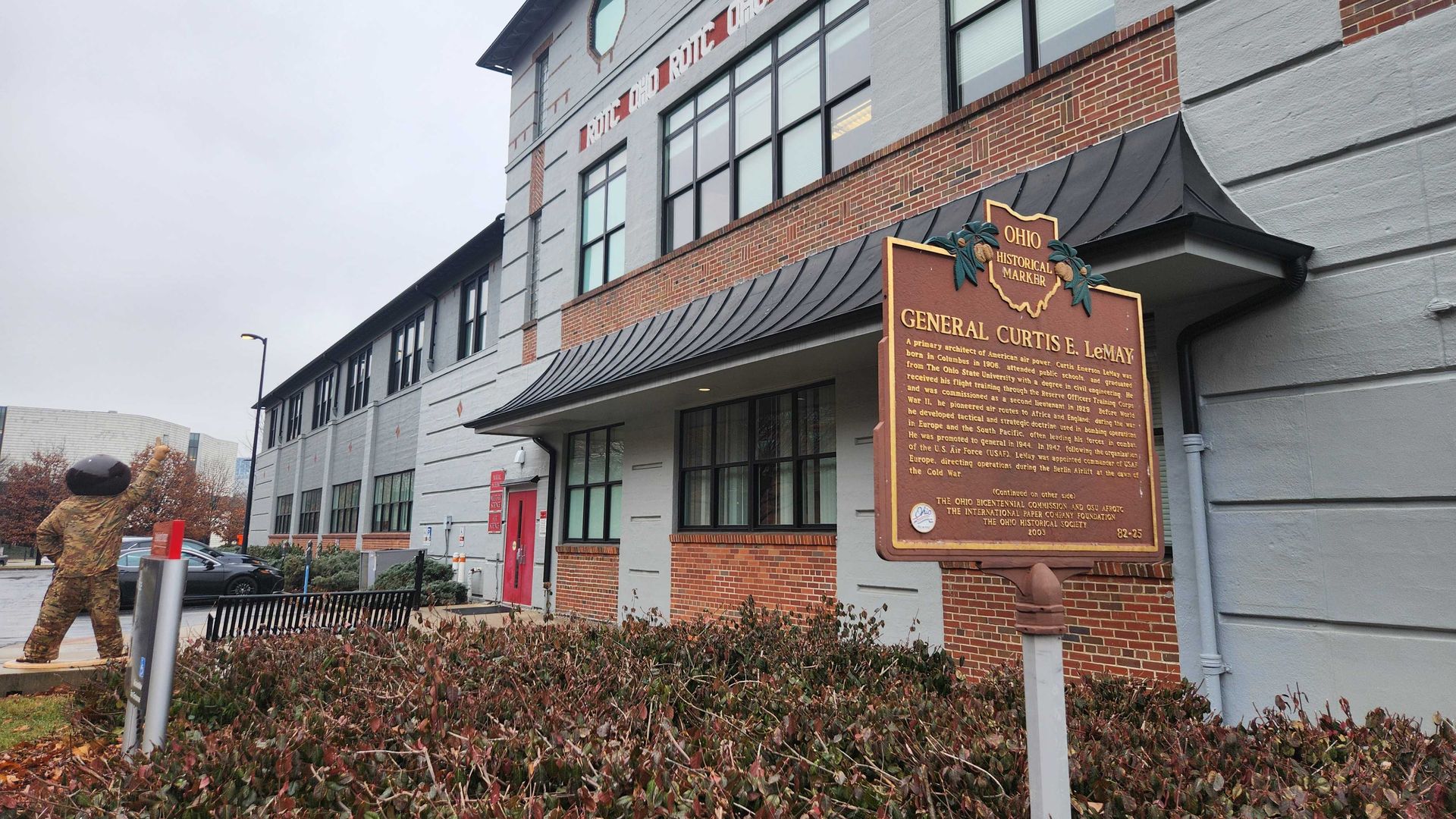 A historical marker for General Curtis LeMay stands next to a building for the Ohio State University ROTC. 