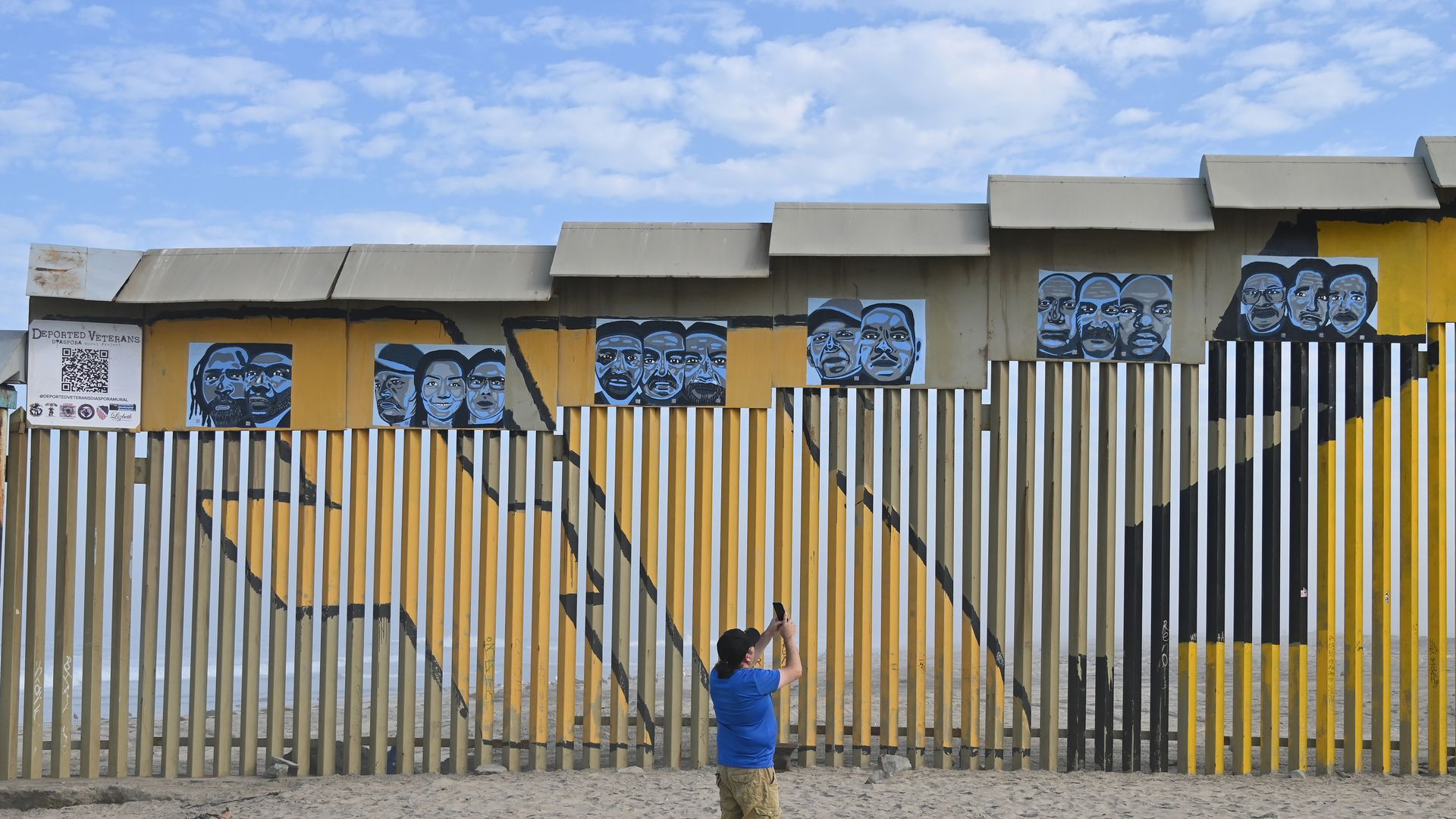 A man takes pictures with his cell phone of a new interactive mural of deported veterans at the Playas de Tijuana beach border wall, ''The Deported Veterans Diaspora,'' in Tijuana, Mexico, on September 6, 2024. 