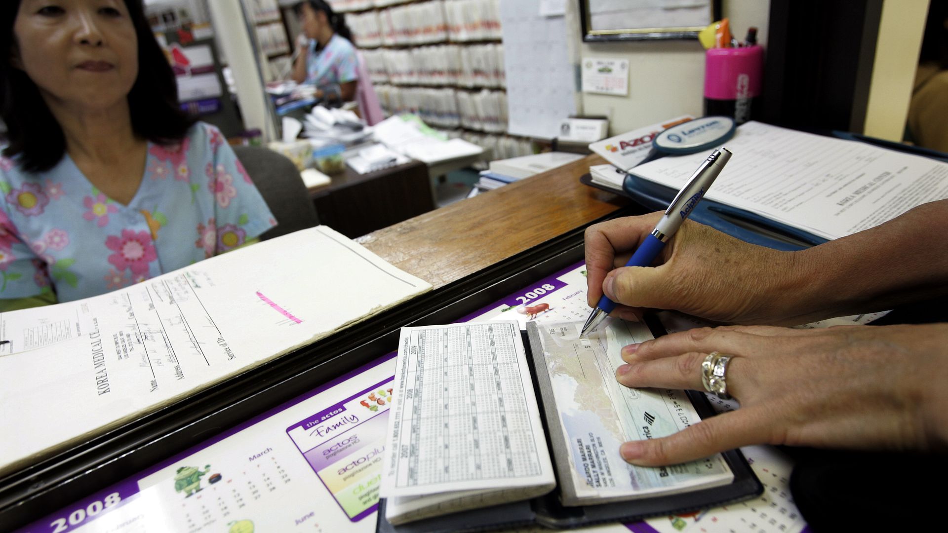 A patient writes a check at a doctor's office.